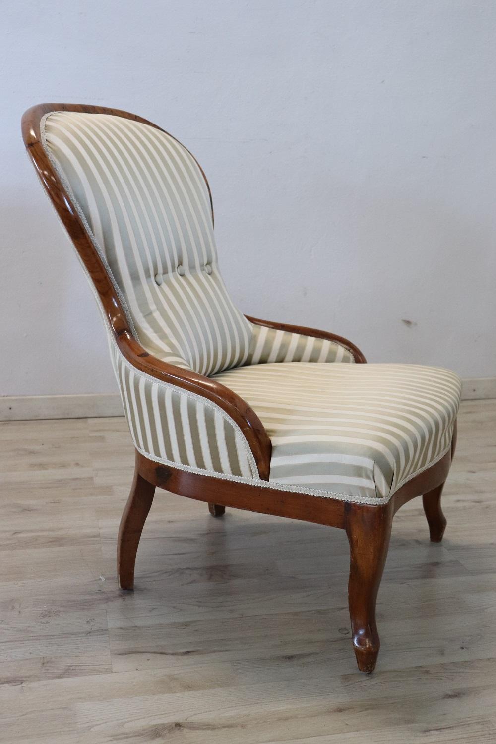 Lovely Italian armchair in solid walnut. This beautiful armchair has an enveloping shape and a comfortable seat with silk. The enveloping and relaxing backrest.
 
