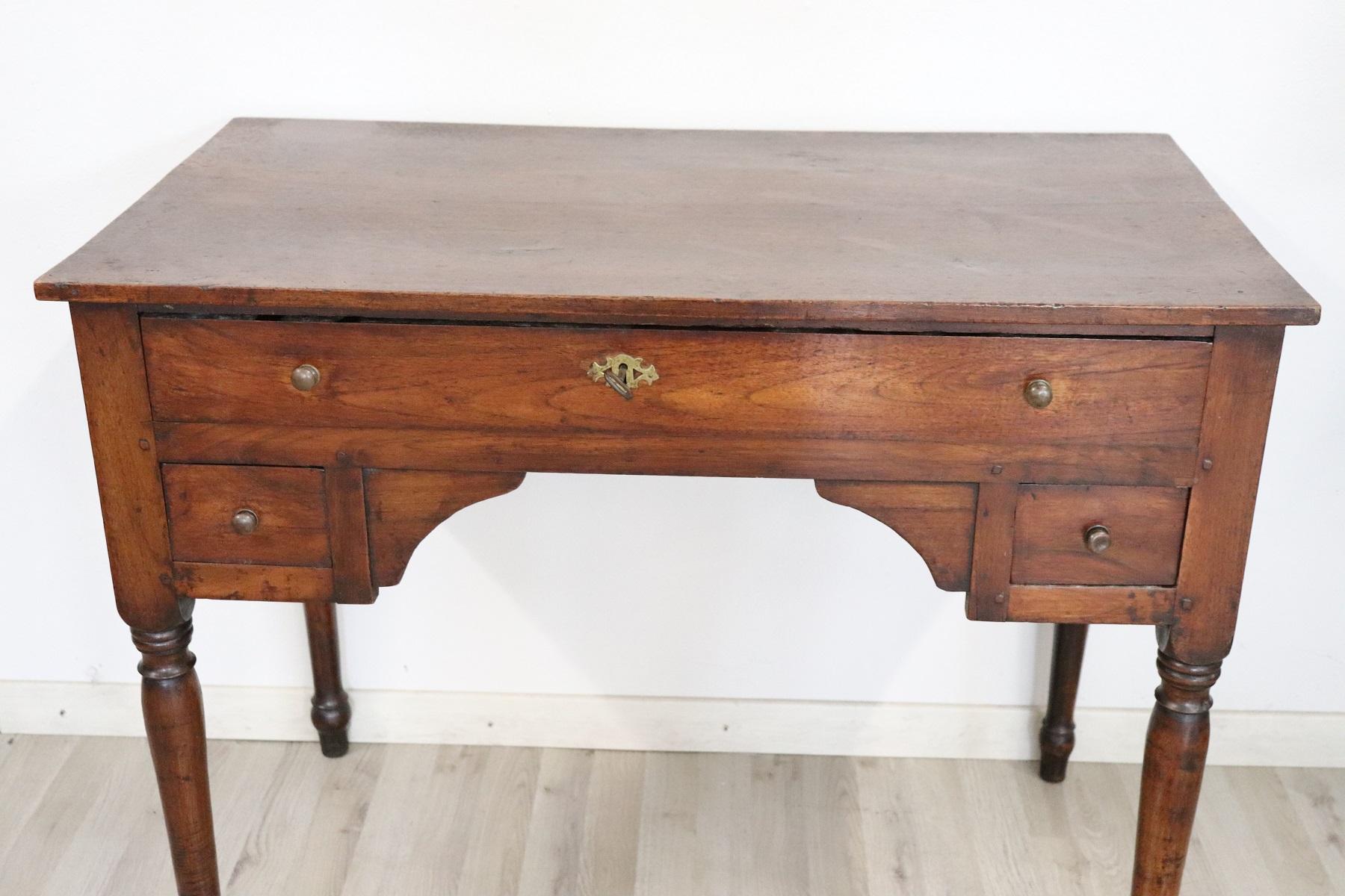 Elegant and essential antique Italian writing desk. Louis Philippe period with classic shapely legs . has a long drawer and two small drawers on the front. Rare and precious walnut. The back of the desk is rough because it is designed to be placed