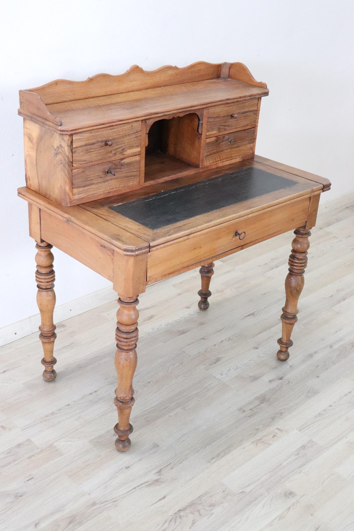 Elegant and essential antique Italian writing desk. Rare and precious solid walnut wood. Comfortable size for a practical use. The desk has elegant turned legs. In the lower part one large drawer and in the upper part four smaller drawers. The top