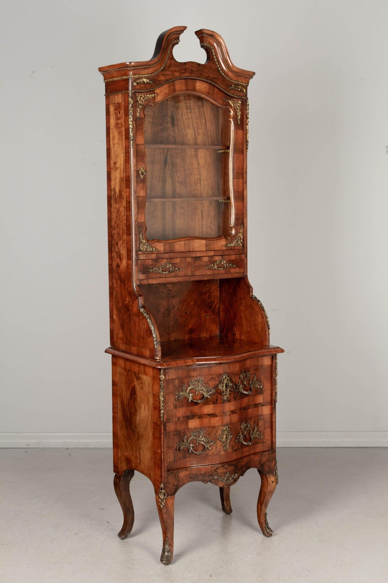 A fine 19th century Italian Louis XV style bronze mounted cabinet with vitrine. Made of solid walnut and pine as a secondary wood. Beautifully patterned book-matched veneers of walnut and burled walnut. In two parts: the vitrine has a tall arched