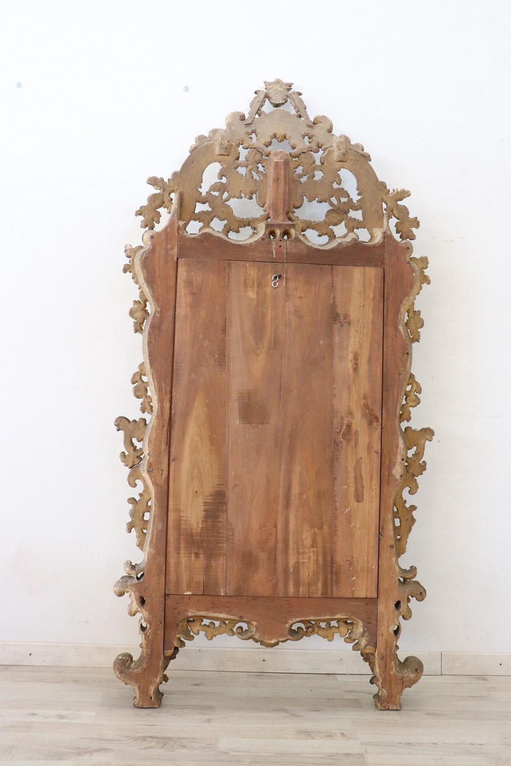 Beautiful elegant large wall mirror in perfect italian venetian Louis XV style, 1850s. Hand carved wood with finely and richly swirls and curls. Refinement decorated in mecca gilding. In good antique conditions. The mecca gilding has a beautiful