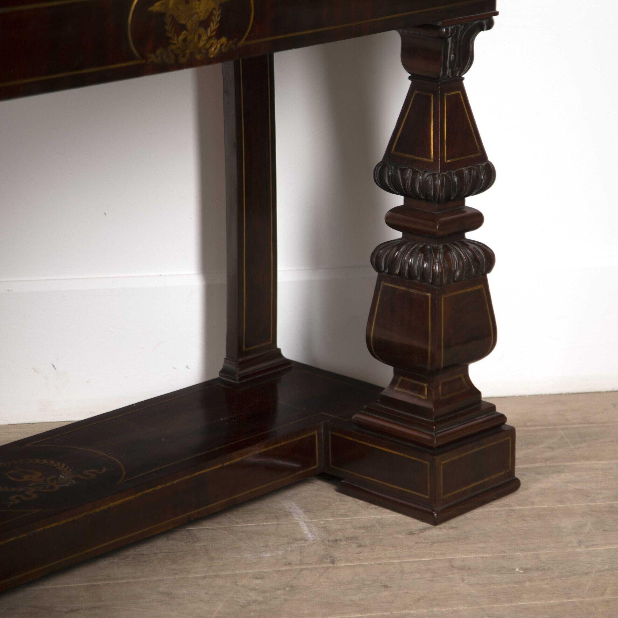 19th century Italian console table with finely inlaid brass detailing.
The front apron is centred by an eagle with outstretched wings surrounded by a wreath sitting on a tied ribbon.
The plinth base is inlaid with a lyre motif and again surrounded