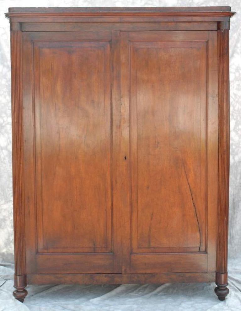 19th-century Italian mahogany armoire with simple, Classic lines. Mounted on carved turnip feet, the piece features two single-paneled doors flanked a slim columnar balustrade on either side.

Italy, circa 1840

Dimensions: 69W x 24D x 93H.