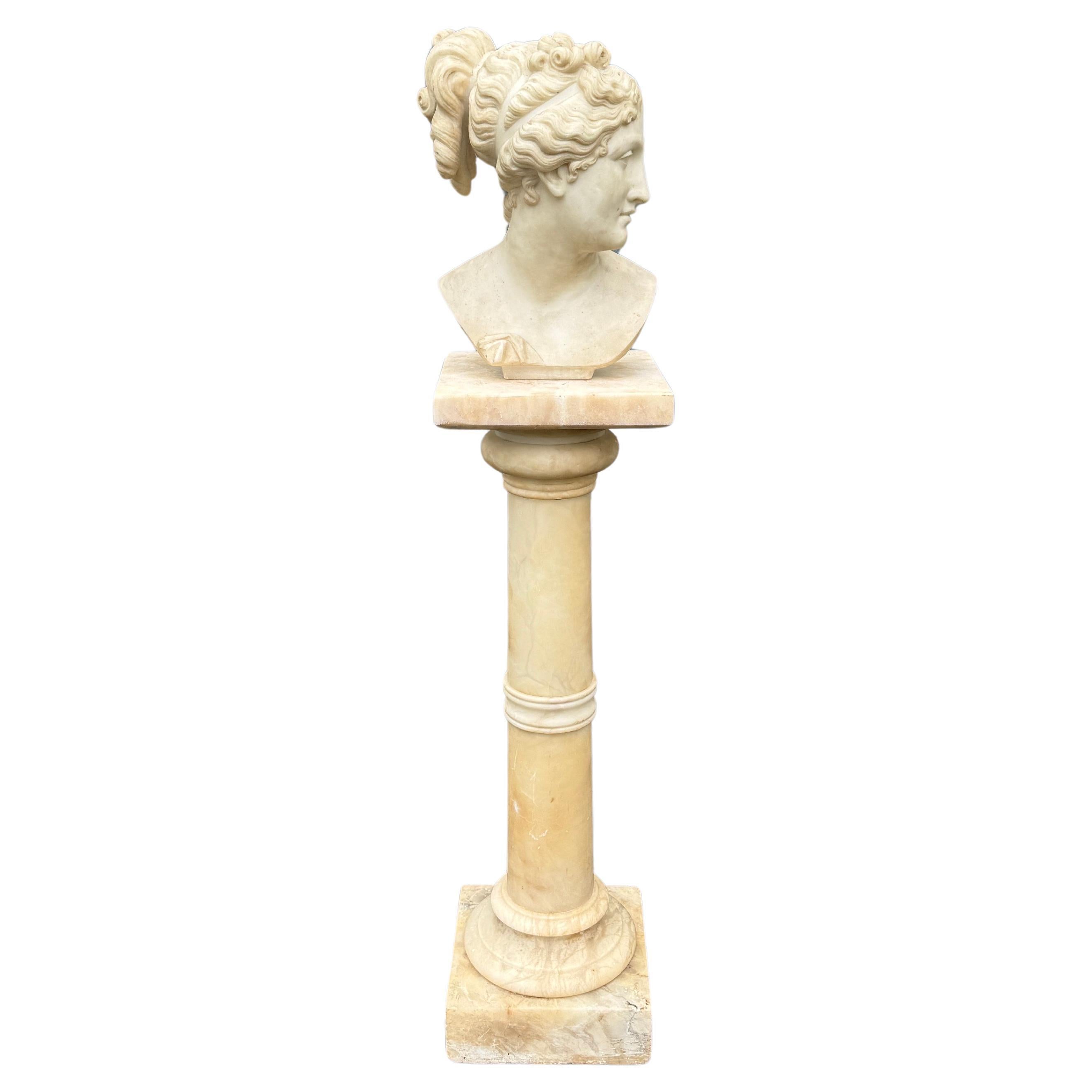 An exquisite marble bust from the 19th Century portraying a female figure.  A true testament to the craftsmanship of the Classical Roman era, this piece stands atop a 3 piece white marble pedestal base, making it a stunning focal point for any