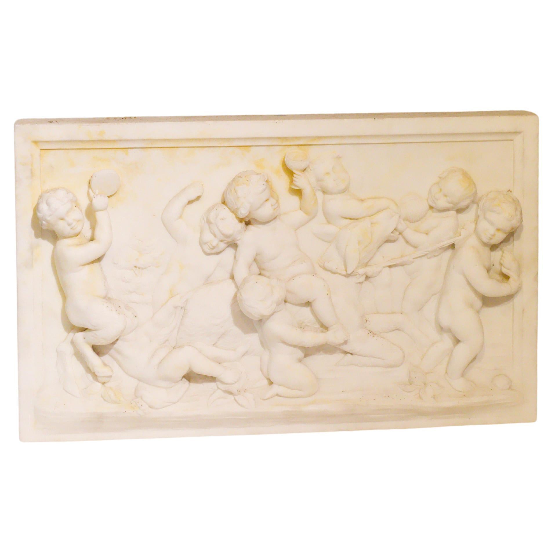 This exquisite 19th-century Italian marble plaque features a finely carved relief of playful cherubs, rendered in the Rococo style reminiscent of the celebrated French sculptor Clodion (1738-1814). The detailed craftsmanship is evident in the