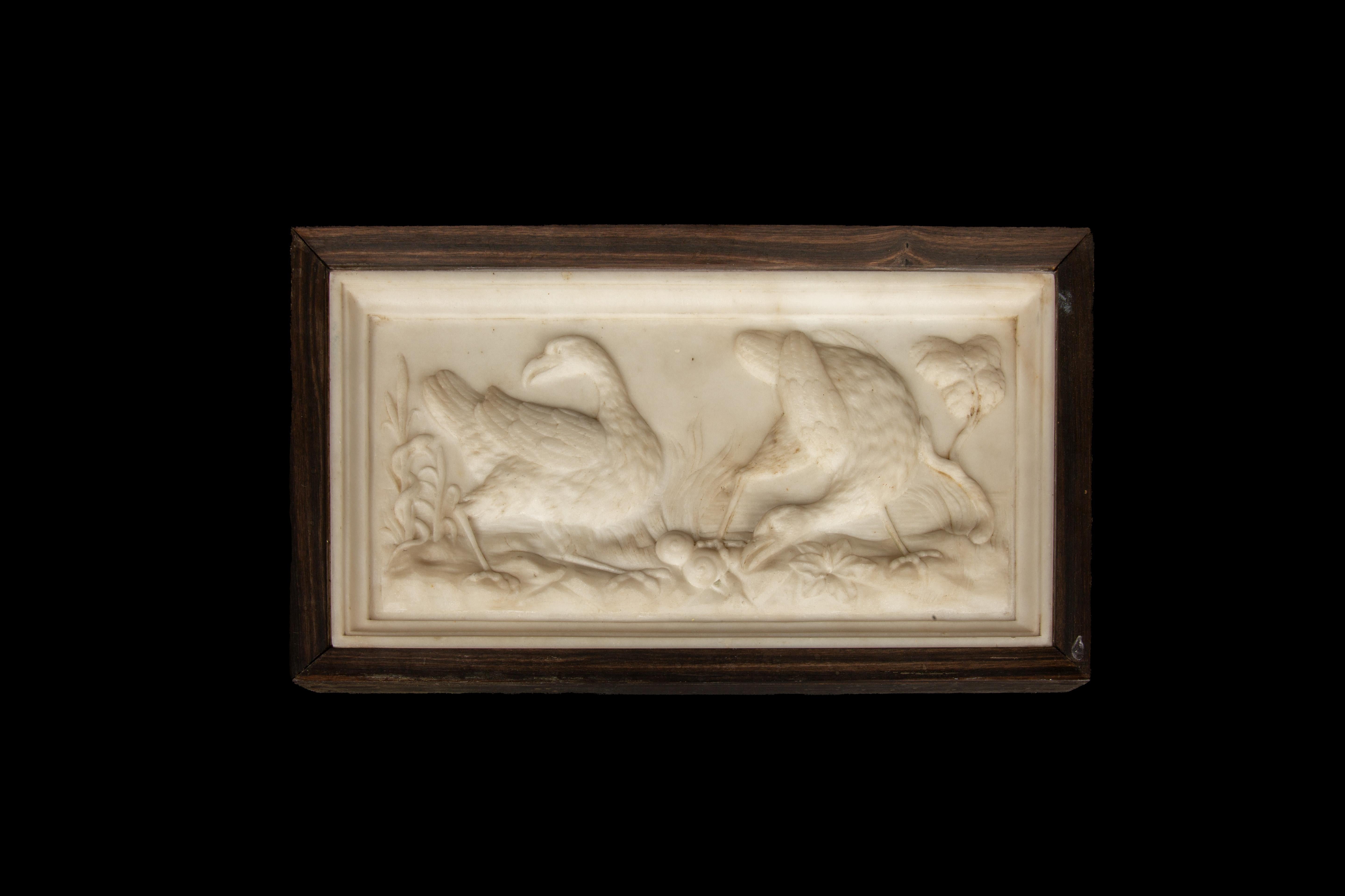 Exquise plaque en relief en marbre italien du XIXe siècle, méticuleusement sculptée à la main pour capturer l'essence gracieuse d'un couple d'outardes majestueuses au milieu d'une végétation luxuriante. L'attention méticuleuse portée aux détails de