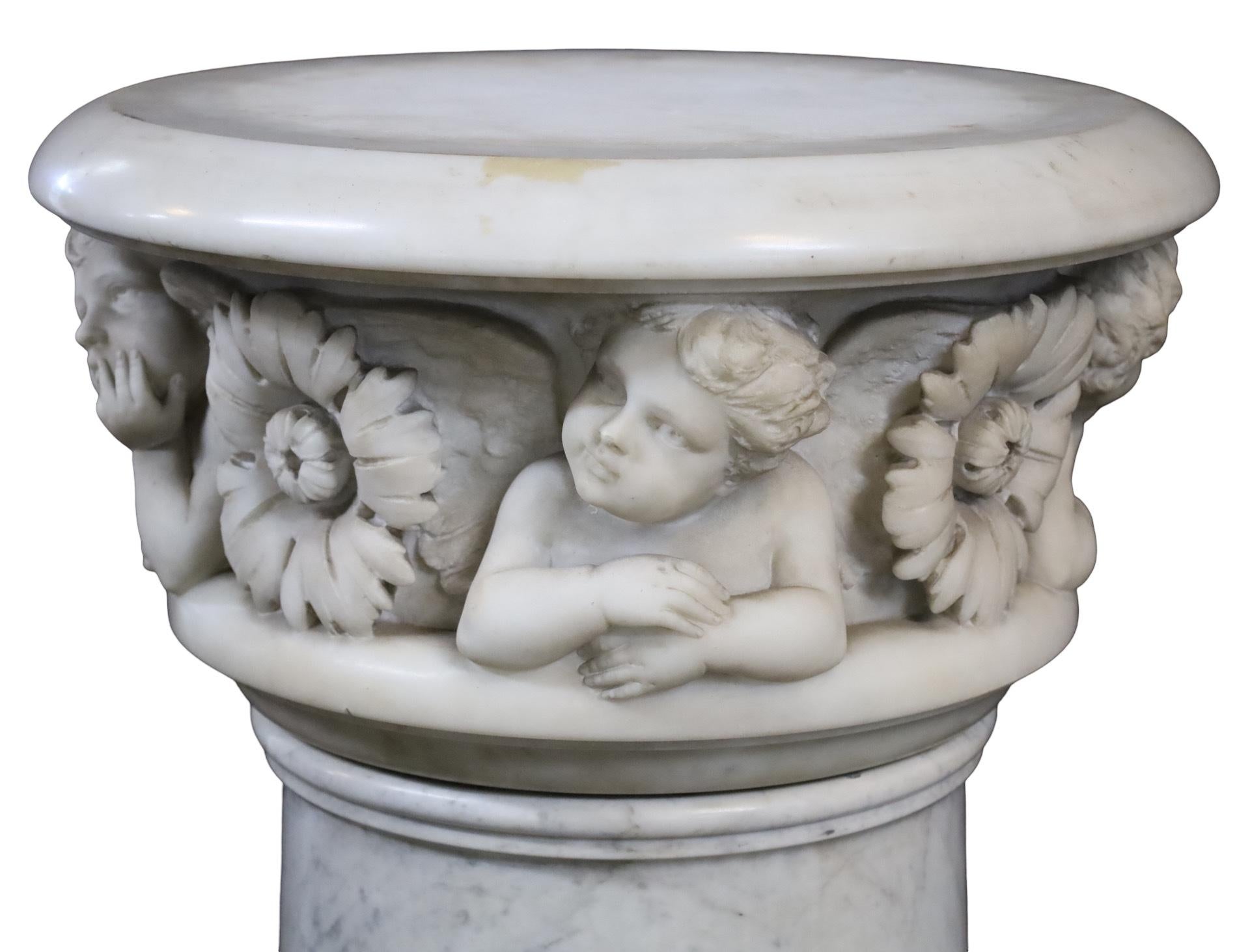 Large hand carved Italian marble pedestal with revolving top, having cherub and rosette carved frieze, the tapered column lowering to an octagonal plinth, 19th century