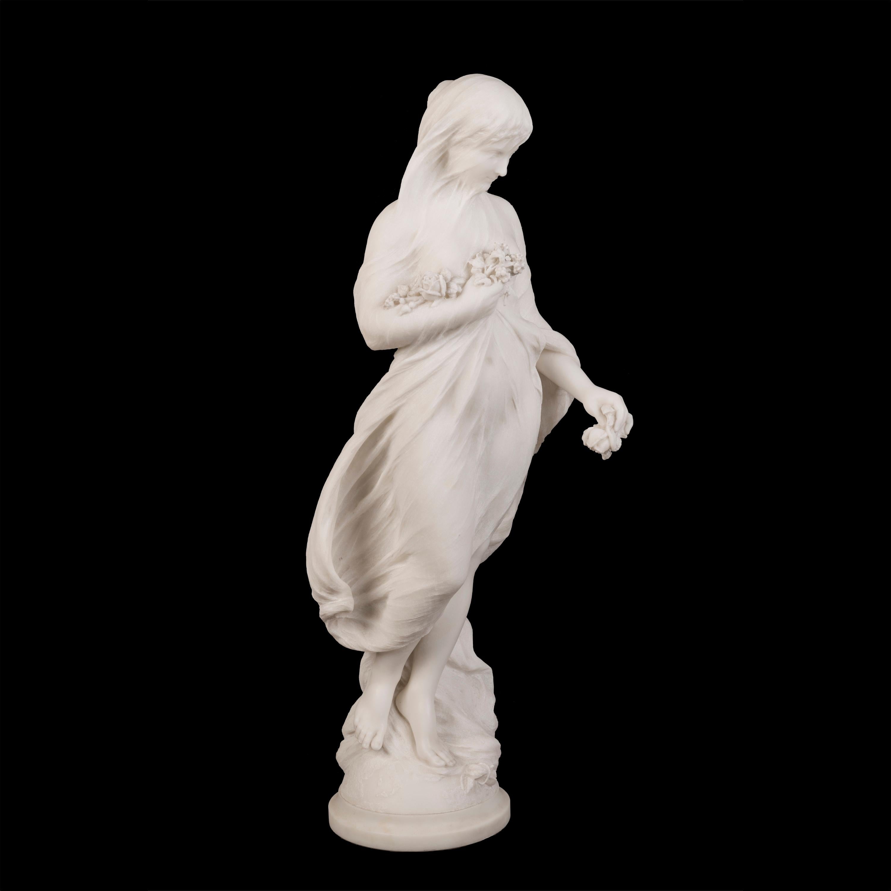 A Marble Sculpture of Flora
By Ernesto Gazzeri

Carved from statuary marble, the veiled maiden standing on a rocky outcrop on a circular base, her flowing dress billowing in the wind as she holds a bunch of flowers in her right arm; her eyes