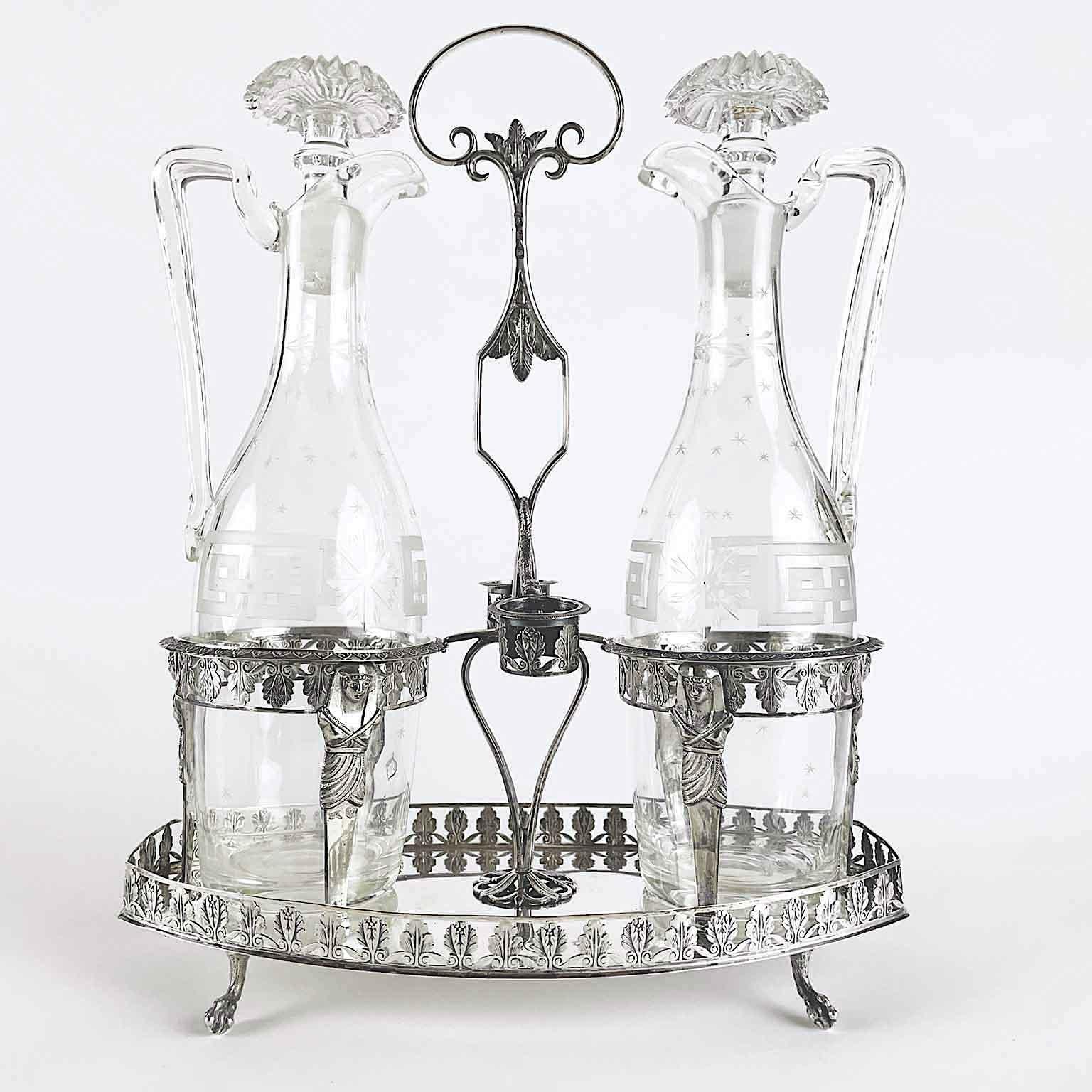 Antique Milanese silver oil cruet consisting of an oval tray supported by four cast zoomorphic paw shaped feet; the edge of the tray is a ribbon decorated by two different shapes of palmette, the same pattern ornates the cruet holders and stopper