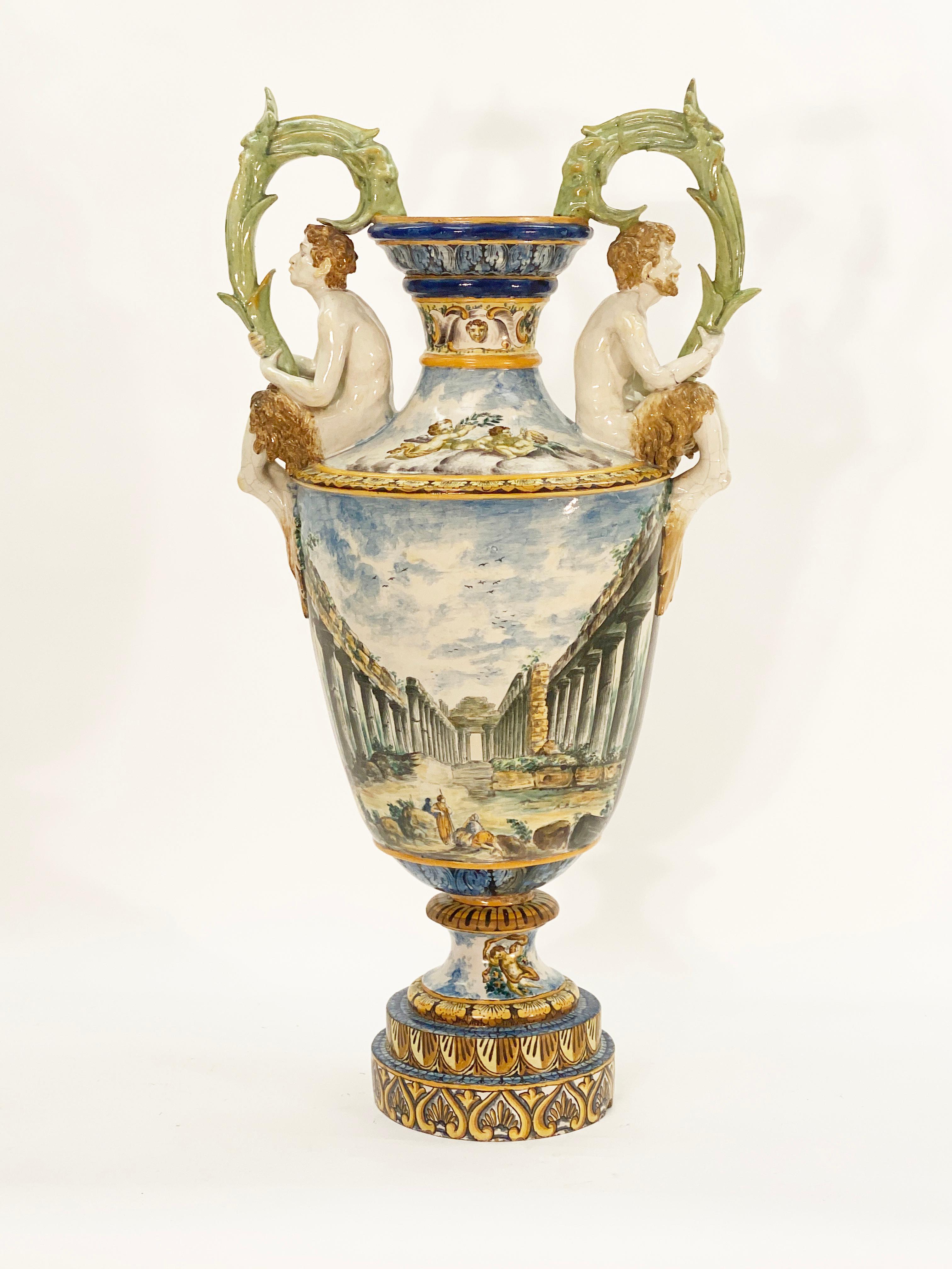 Monumental Italian Majolica porcelain figural floor urn. Decorated throughout with hand painted Classical Greek scenery. Two figural fawns on the opposing handles. Fine wear and cracks on the glazing that indicate age. 

Italian circa