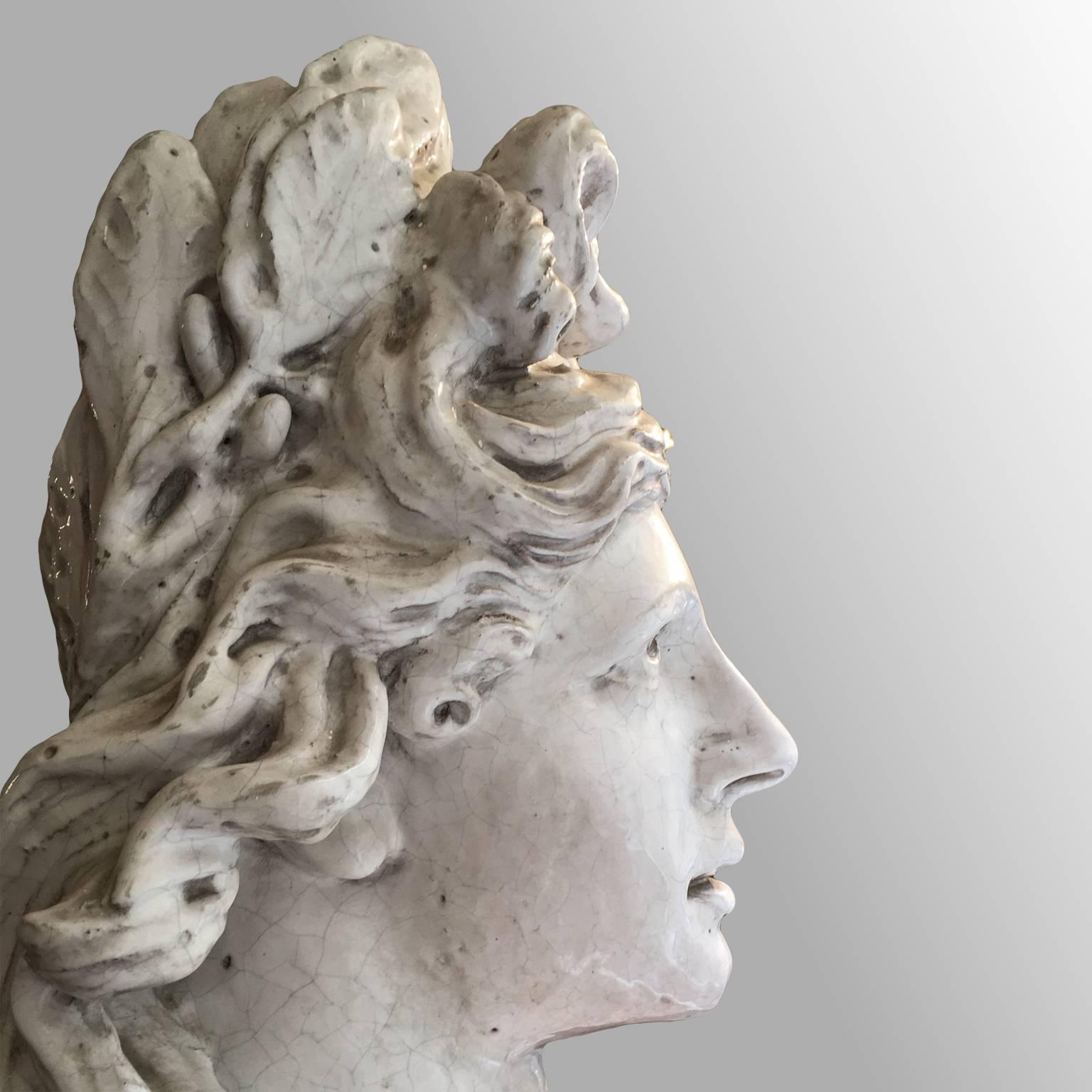 A stunning Italian terracotta bust of great size
Bust depicting a female figure with a laurel crown, the allegory of victory.
The beautiful bust with its white, glazed surface
stands on a circular, colorful glazed terracotta base.
Italian