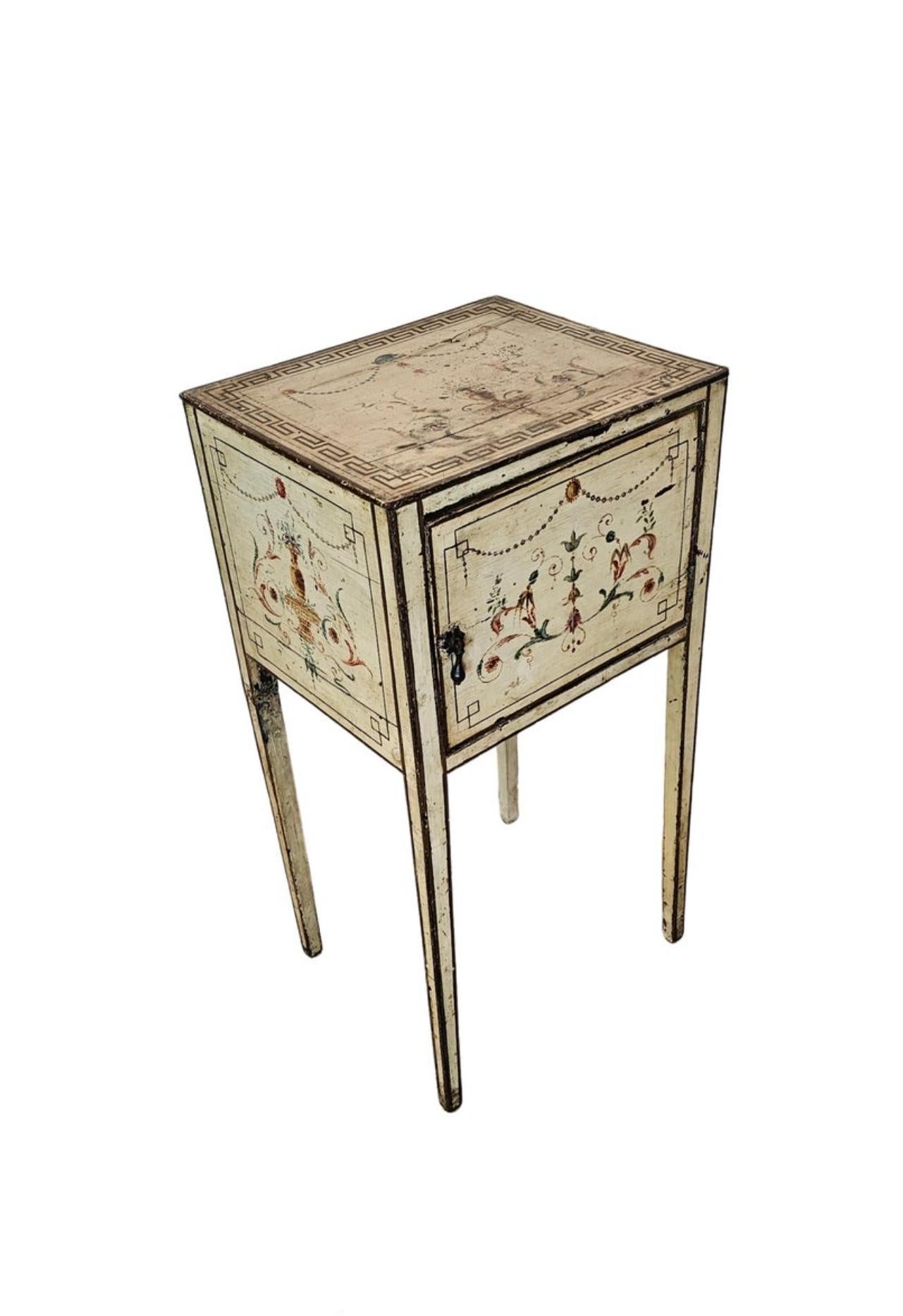 A most charming antique Italian Neoclassical style paint-decorated bedside cabinet with beautifully aged heavily distressed patina. 

Born in Italy in the late 19th century, hand-crafted solid wood construction, antique cream base ornamented in