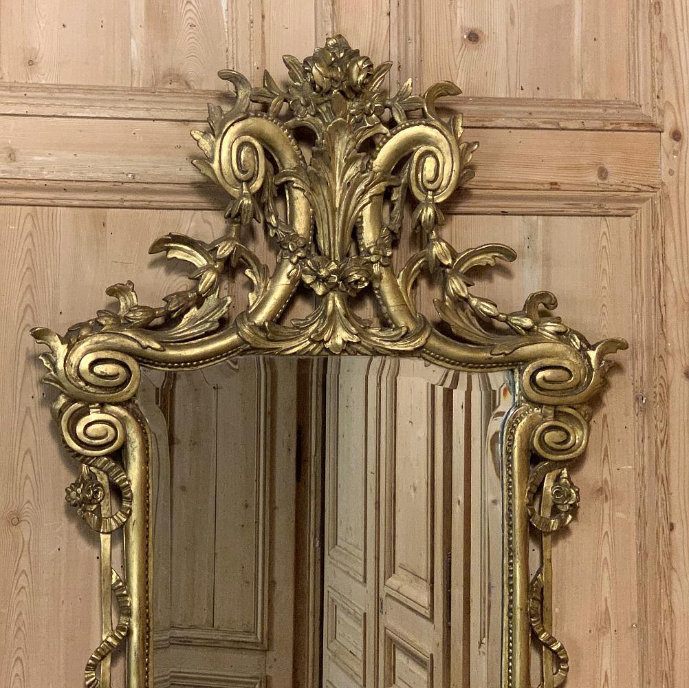 Le miroir néoclassique italien du XIXe siècle en bois doré sculpté combine des formes naturalistes dans une présentation symétrique avec l'architecture gréco-romaine classique pour créer un effet visuel époustouflant.  Comme c'est le cas dans