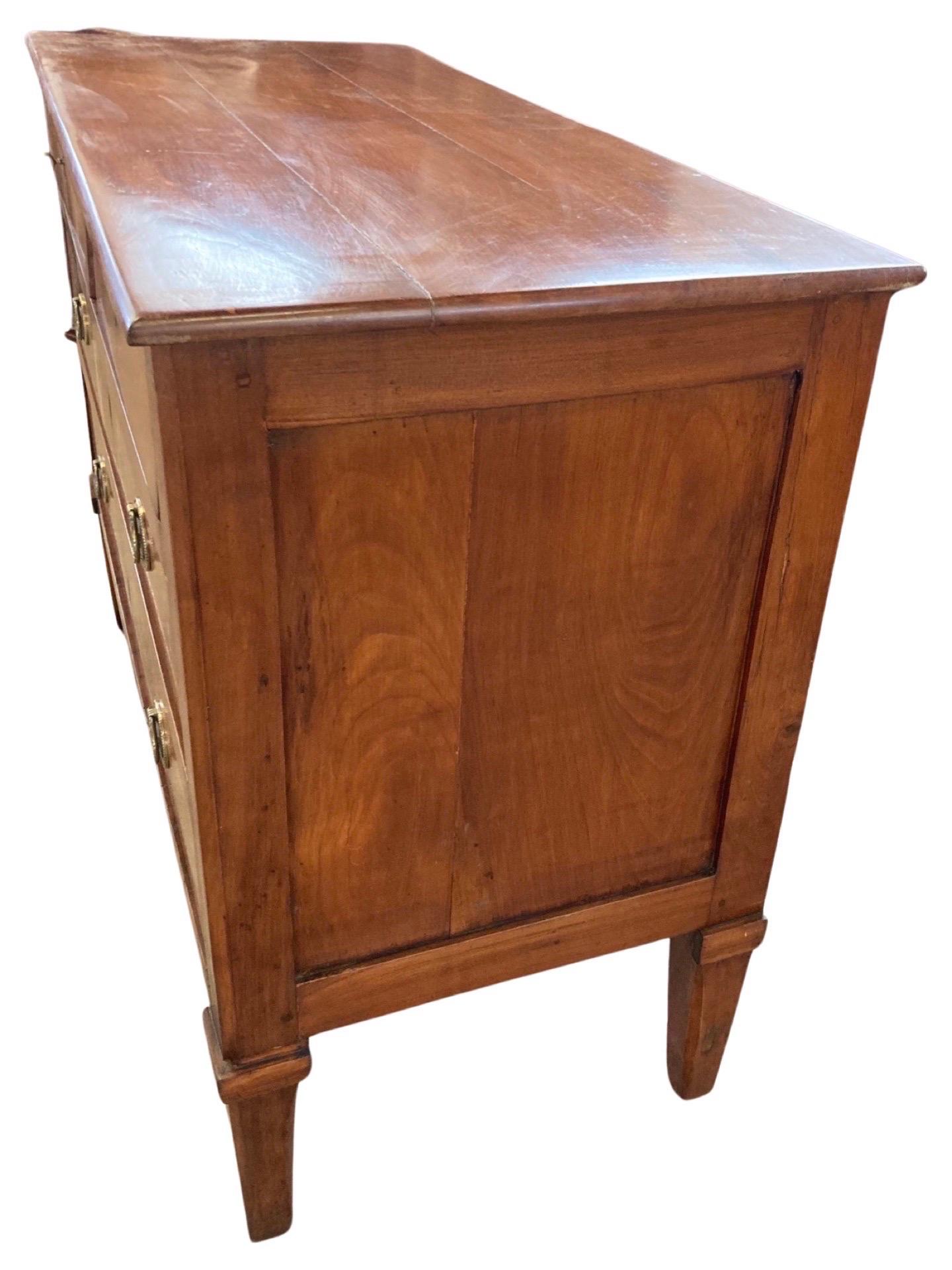 Neoclassical commode hand-made in Italy in the early 1800s using cherry and pegged construction. This is a beautifully-made and fully functional two on two chest of drawers. The chest features two small inset drawers on top of two larger inset