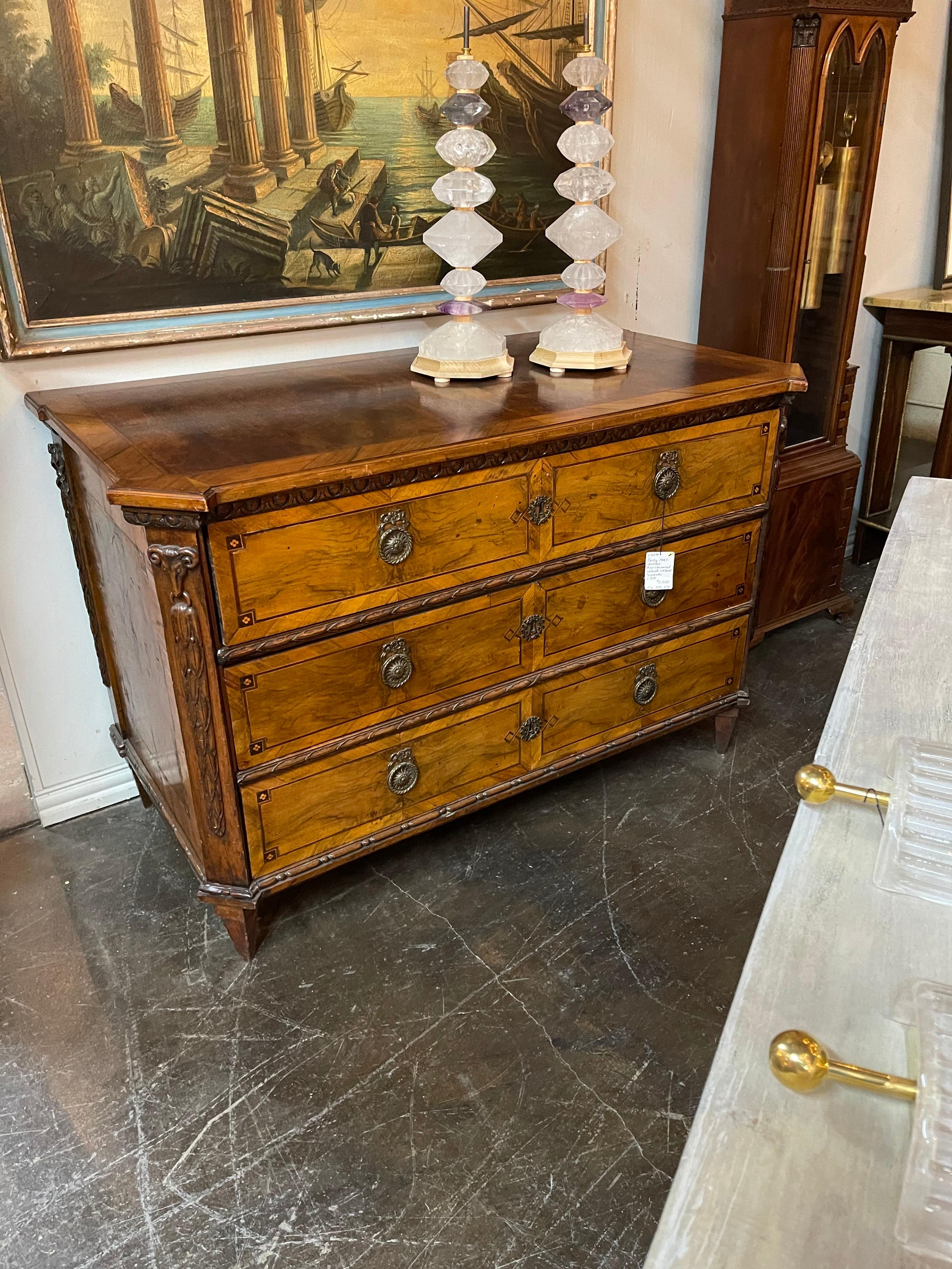 Superb quality early 19th century Italian neoclassical mahogany commode. The three long drawers having old bronze escutcheons and pulls flanked by canted corners with nicely detailed relief carvings. The entire on delicately tapered
