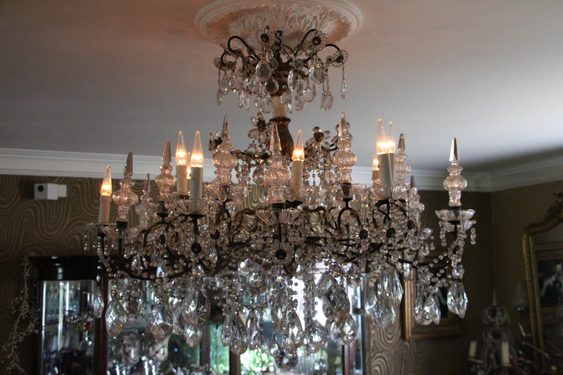A most charming Italian 19th century pressed patinated metal, giltwood and crystal twelve lights Genovese chandelier. This magnificent chandelier features 2 tiers of 6 lights each. Its giltwood and patinated ivory painted central fut. displays