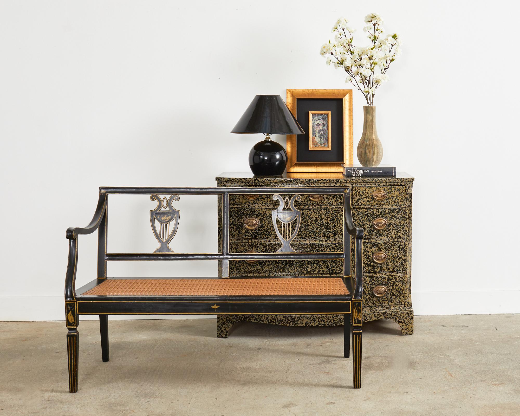 Dramatic 19th century Venetian style Italian bench seat or settee featuring a black lacquer painted finish with parcel gilt accents. The elegant frame of the bench is carved with gracefully curved arms and arm supports. The back splat has a lyre
