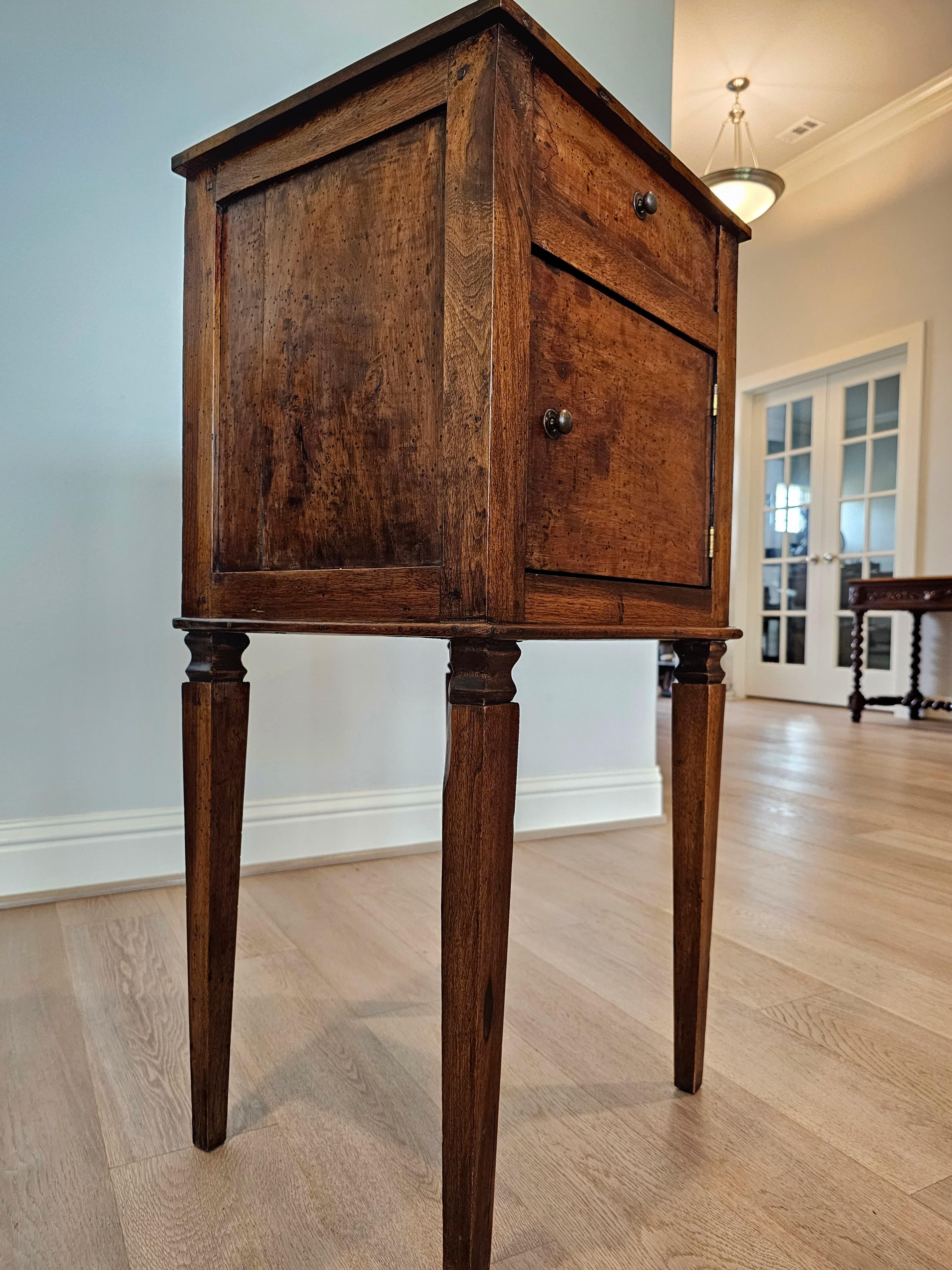 A rustic antique Italian country Neoclassical style walnut side cabinet with beautifully aged patina. 

Hand-crafted in Italy in the 19th century, most likely Tuscan region of Central Italy, Neo-classical Louis XVI taste, having single dovetailed