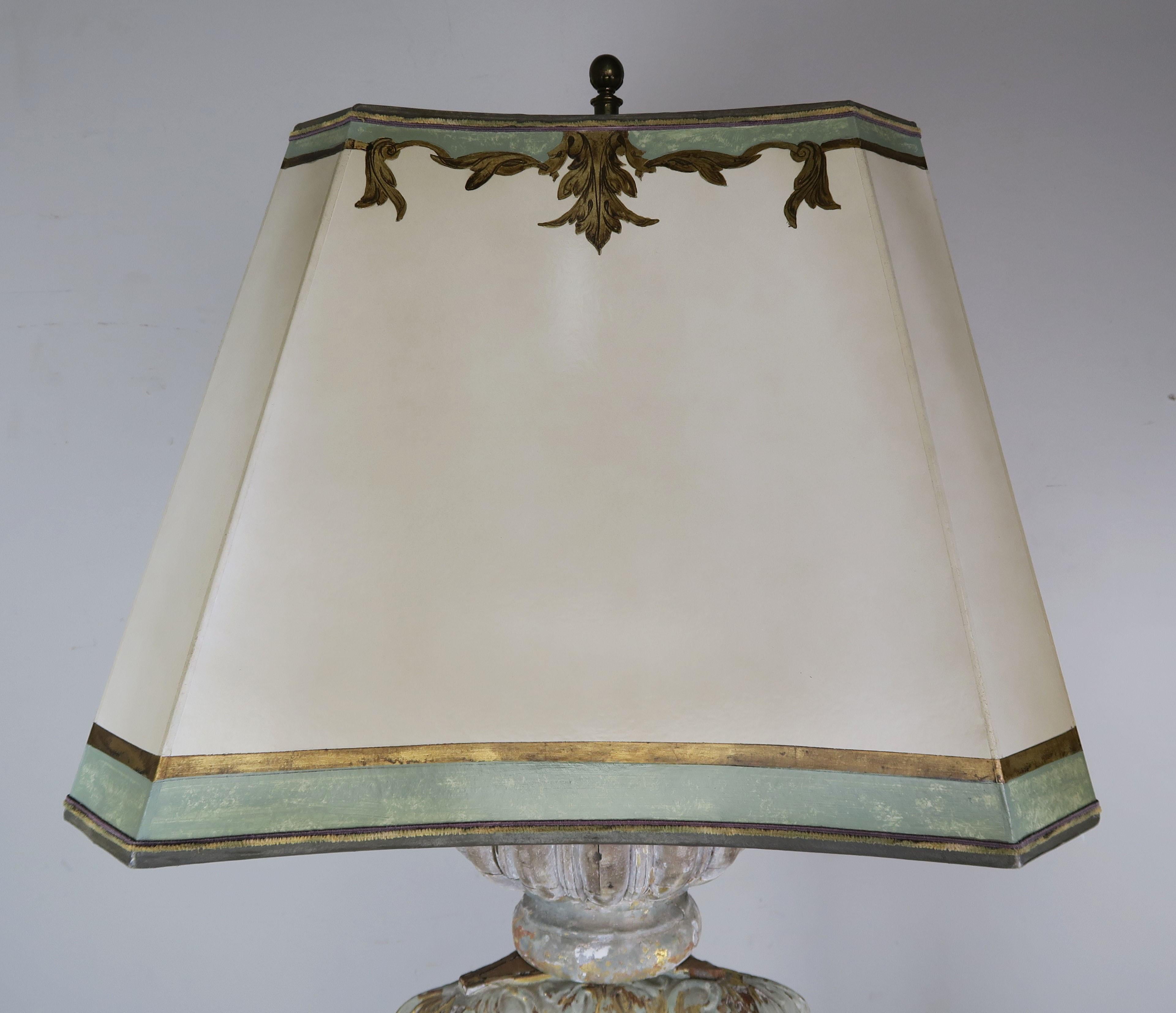 19th century Italian painted torchiere that has been wired into a standing lamp and crowned with a hand painted square shaped parchment shade with tapered corners. The torchiere Stand on a scrolled tripod base and has intricate carved details that