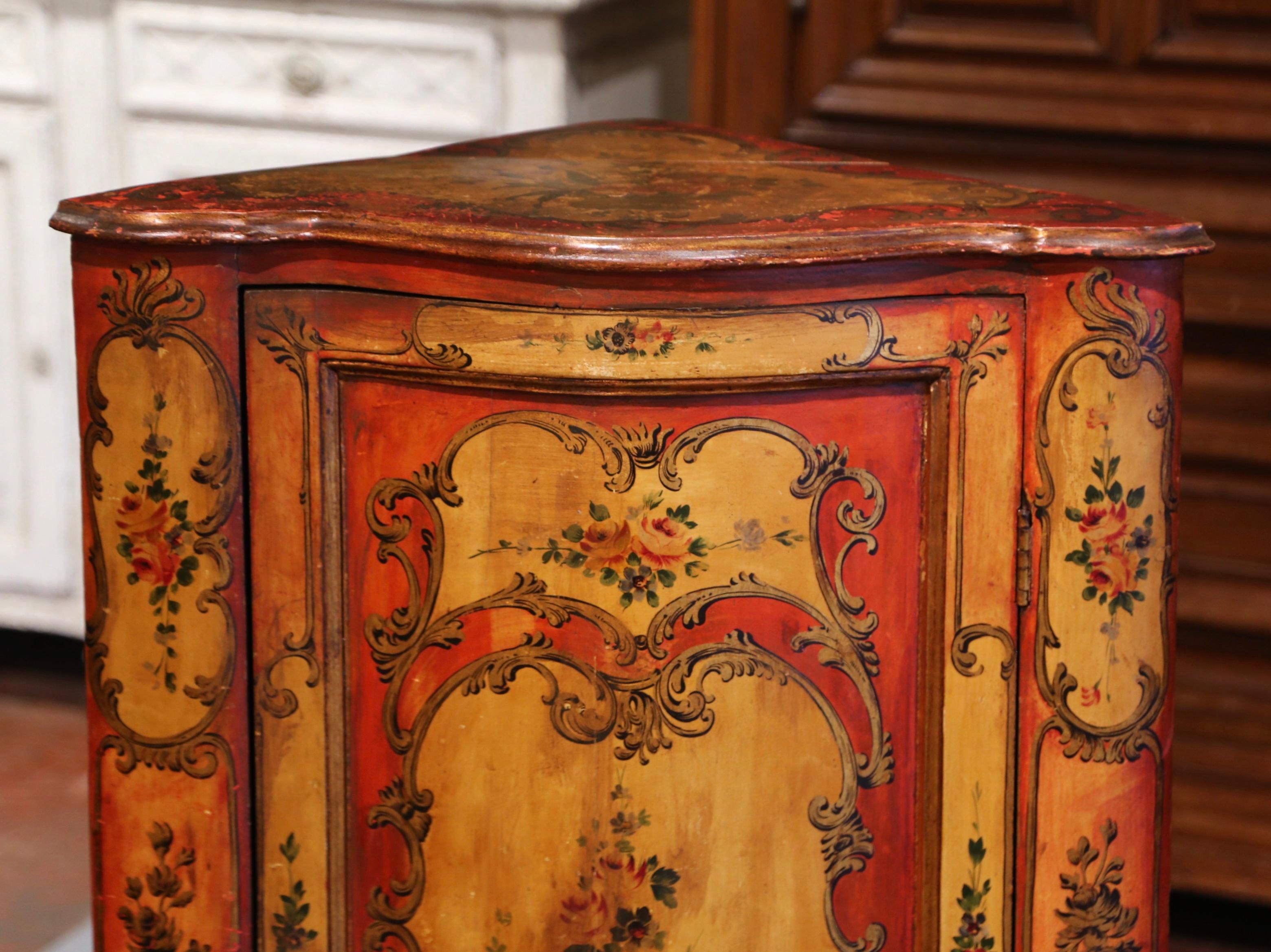 This elegant and colorful antique cabinet was created in Italy circa 1860. The cupboard features a bombe door across the front opening to inside shelving (two shelves) for ultimate storage. The piece is decorated throughout with hand painted floral