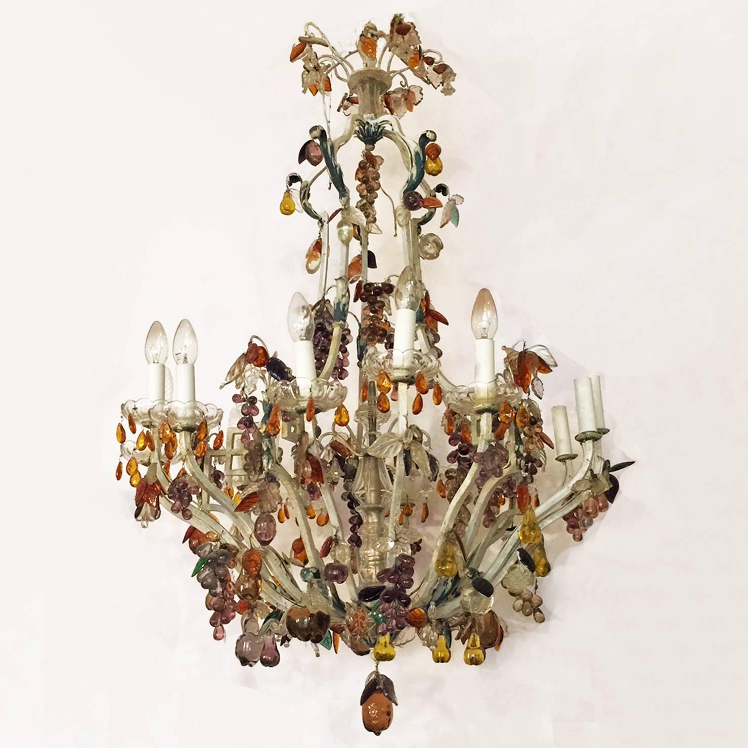 Charming Italian bronze and crystal chandelier embellished with fruit pendants in colored glass.
The main structure of the chandelier features 15 branches in painted bronze.
Each branch has one light and transparent crystal drip pan.
The