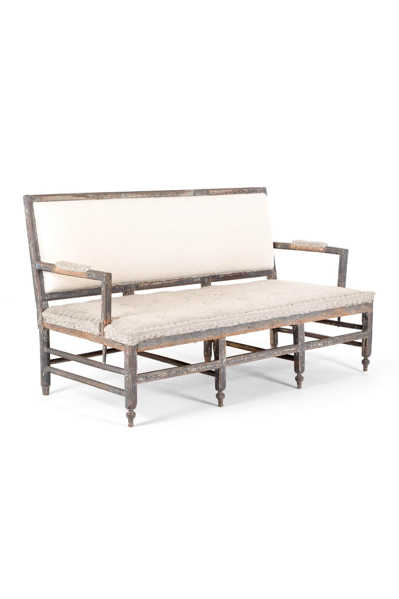 A stunning 19th century sofa or bench settee in a distressed grey painted finish.

The sofa has a wide rectangular padded back with open padded arms and a generous rectangular padded seat.

This model is unusual in its size and elaborate use of