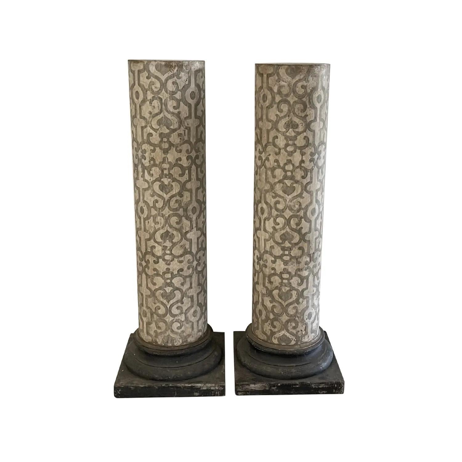 Early 19th century, an antique Italian pair of patinated column pedestals Arte Povera, made of hand crafted Pinewood with a square base in legno laccato hand painted with a continuous geometrical light Tuscan pattern light and dark grey. The top is