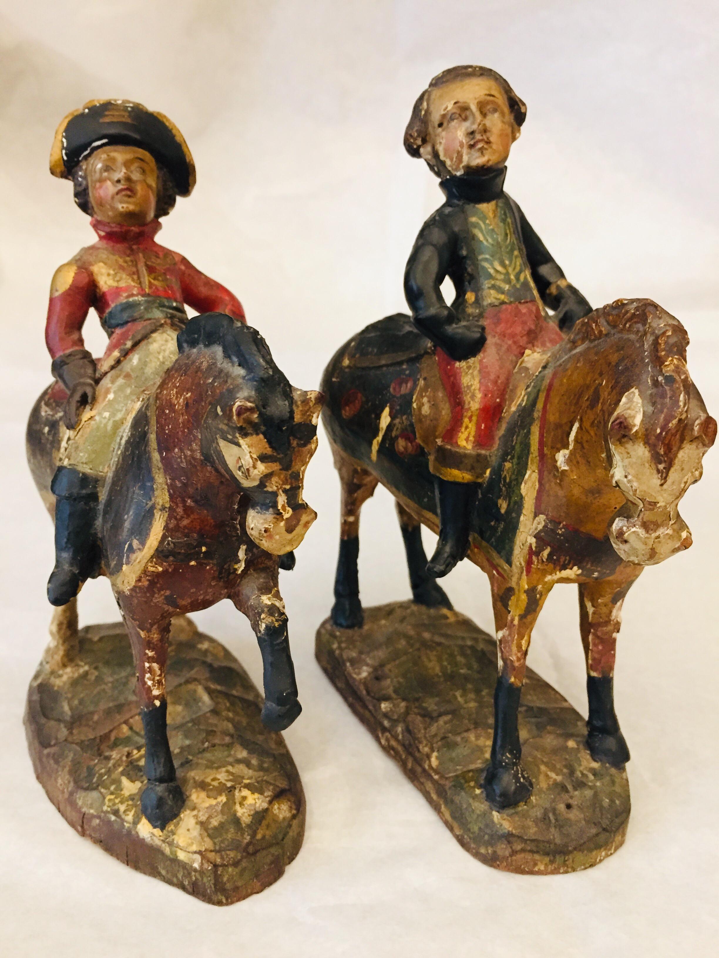 A pair of antique soldier figures with horses of Italian Piedmontese origin, two 19th century soldiers on horseback, hand-carved, gilded and polychrome hand-painted sculptures, realized in Cembran pinewood.

The two knights are wearing different