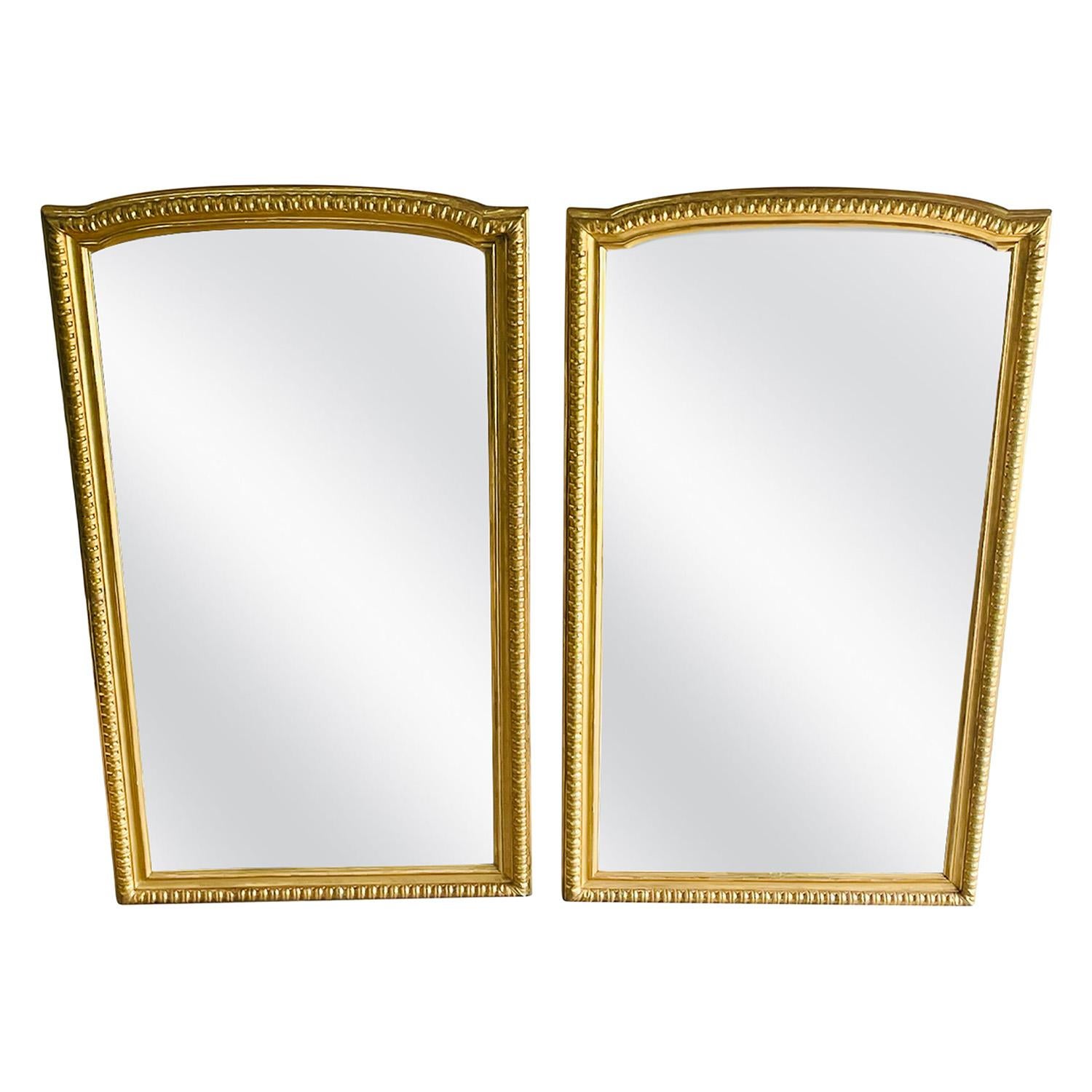 Un gran par de espejos de pie italianos antiguos de madera de pino dorada hechos a mano, en buen estado. Los espejos de pared de pasillo patinados en oro están particularizados por una parte superior arqueada. Pequeña decoloración, arañazos debidos
