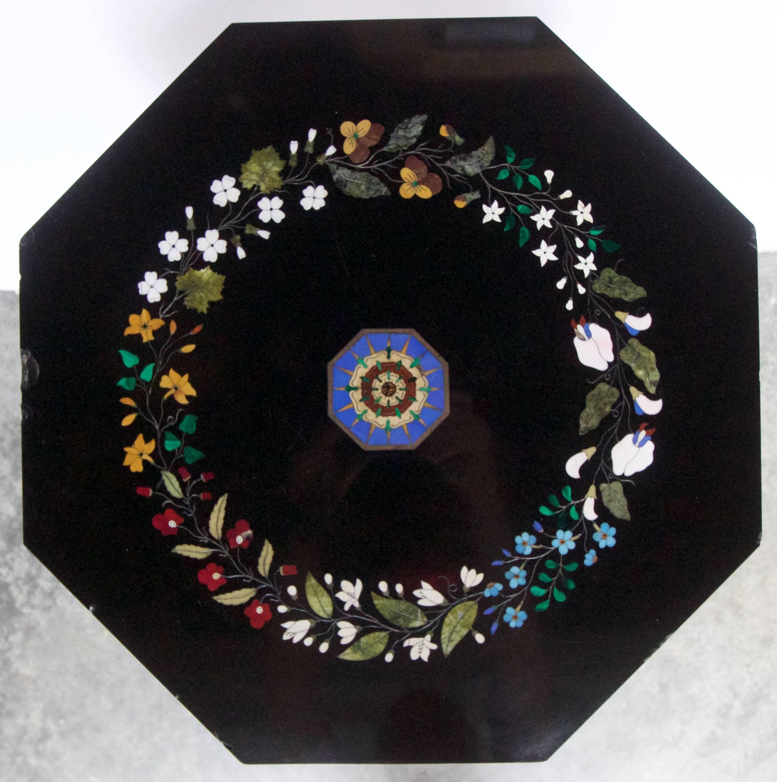 A very fine mid-19th century Florentine pietra dura inlaid decor on an octagonal black Belgian table marble top. The pietra dura inlay depicting a colorful circular guirland of flowers and foliage made of semi precious hardstones such as malachite,