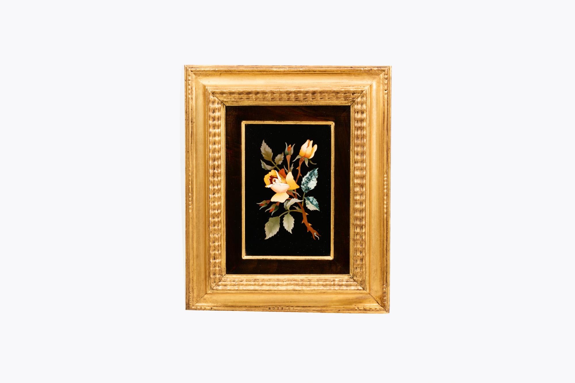 19th Century Italian Pietra Dura framed specimen plaque depicting a branch of blossoming yellow roses. With various semi-precious stones skillfully inlaid into a black marble background. Held in a giltwood frame.