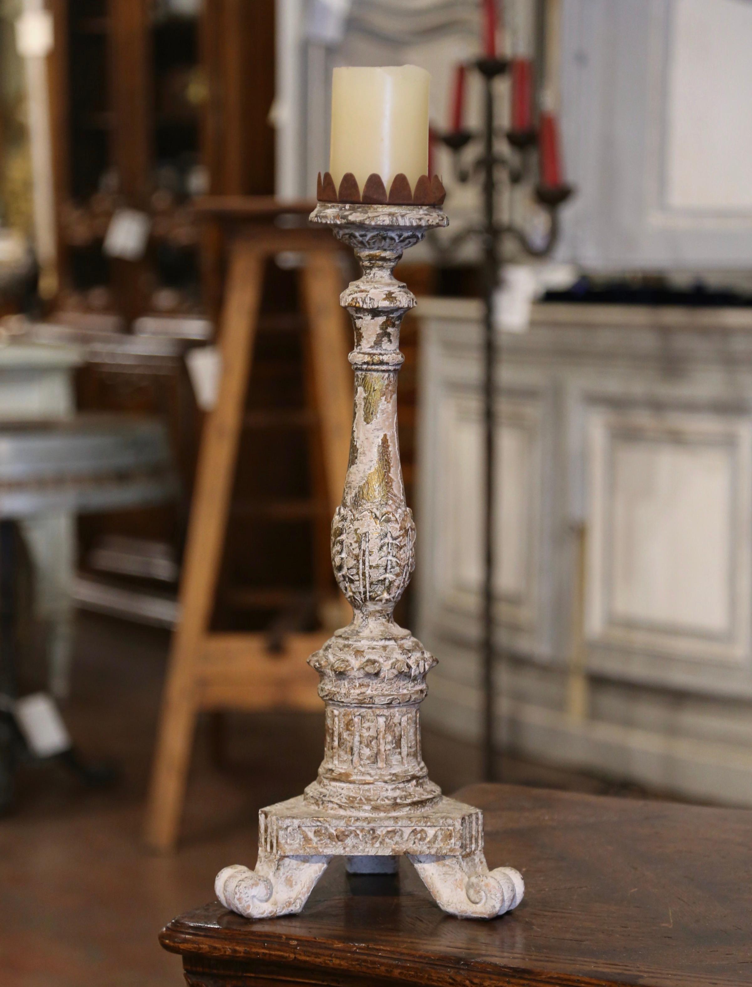 Add an air of drama and elegance to your home with this elegant antique candlestick. Crafted in Italy circa 1880, the candle holder stands on a tripod base ending with escargot feet; the decorative fluted stem is embellished with hand carved leaf