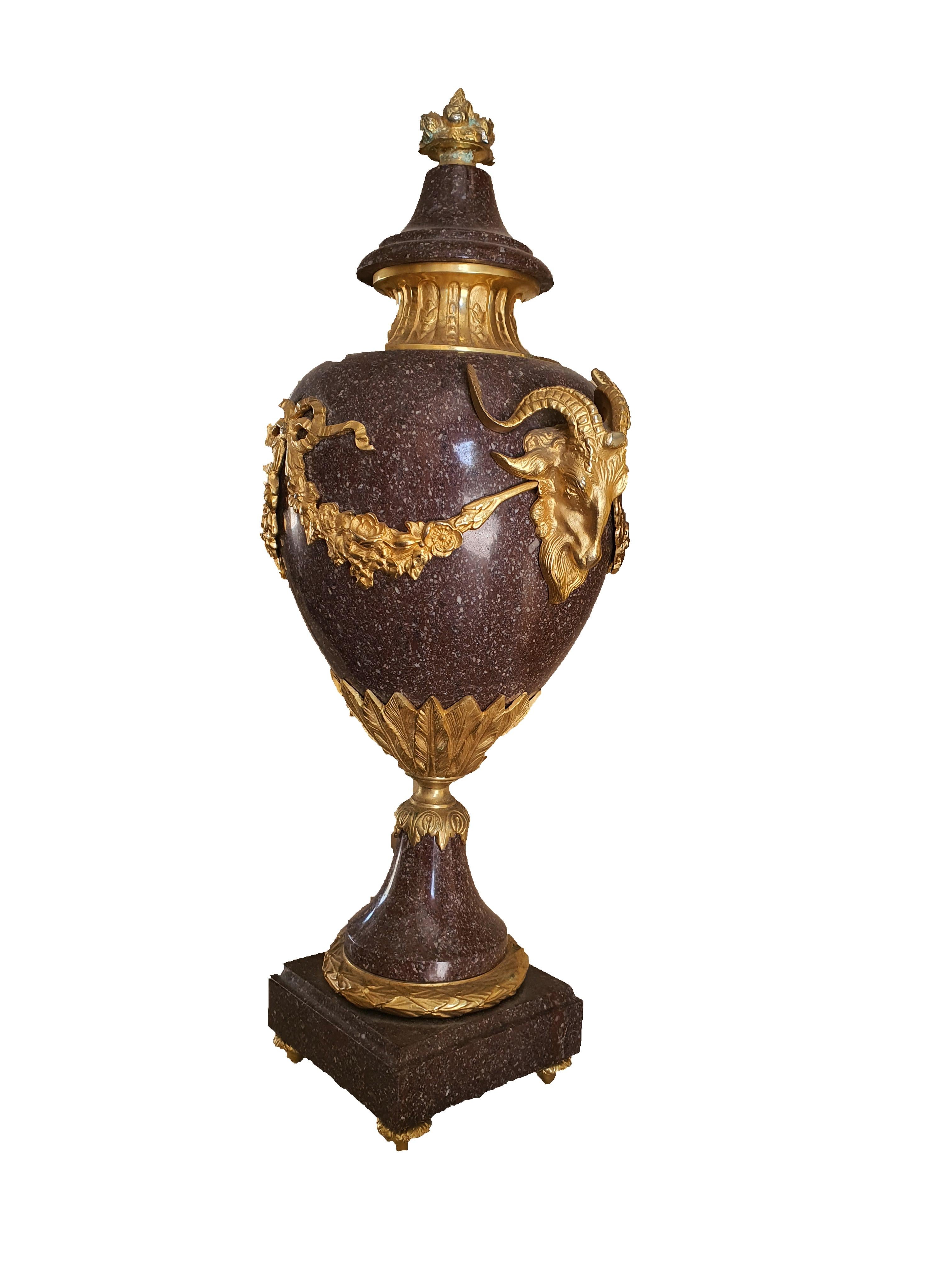 Elegant Italian vase in Egyptian porphyry adorned with precious applications in finely chiseled and gilded bronze. Goat heads in bronze on the sides, joined by a bronze wreath, finely chiseled, with a floral motif.