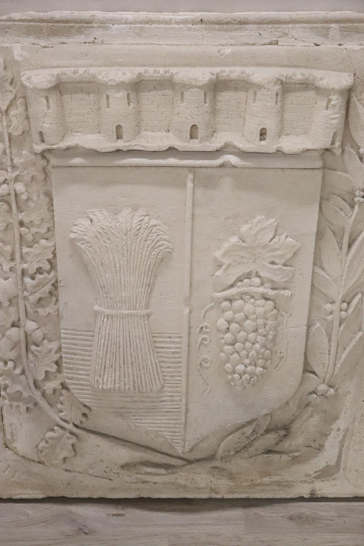 Antikes heraldisches Wappen aus Puzzolan. Puzzolan ist eine antike Zementart. Das Wappen ist sehr groß und stammt von einer Familie, die sich um die Landwirtschaft im Norden Italiens kümmerte. Im Wappen sind ein Weizenbündel und eine Weintraube auf