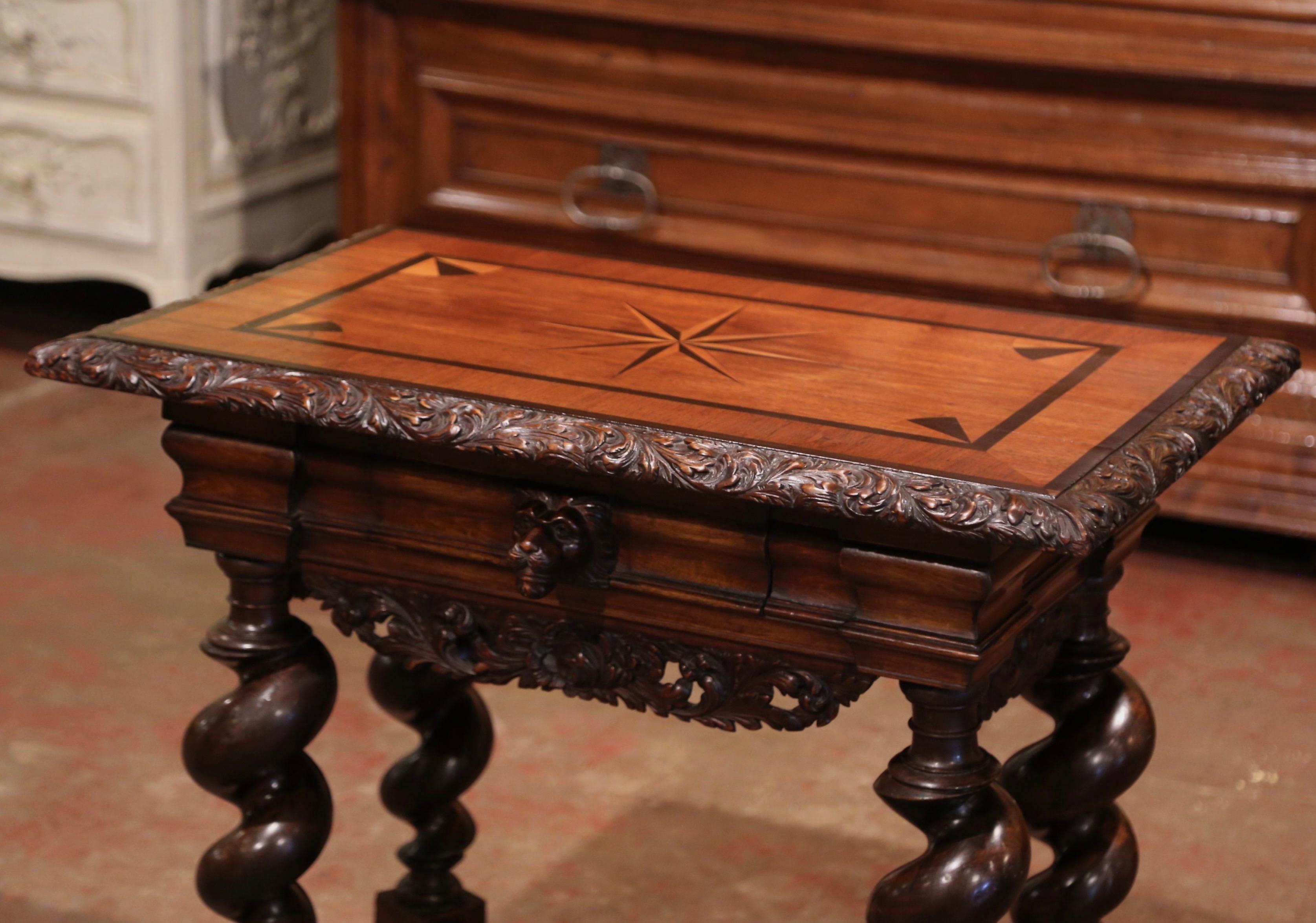 Crafted in Italy, circa 1860, the elegant side table stands on barley twist legs connected with an elaborate X-stretcher at the base and embellished with central round finial. The antique table features a single drawer decorated with a carved lion