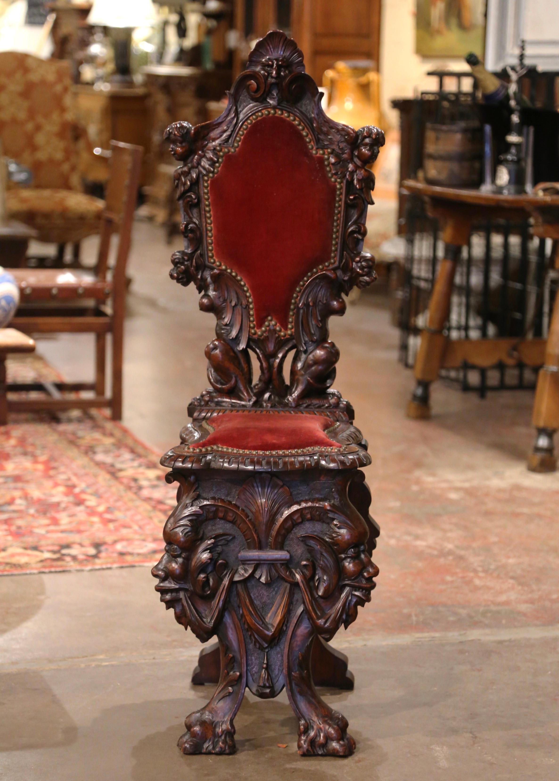 Decorate a hallway with this well carved antique Sgabello chair. Crafted of walnut in Venice, Italy circa 1880, the chair stands on heavily carved legs decorated with acanthus leaves and ending with paw feet. The center is decorated with grotesque