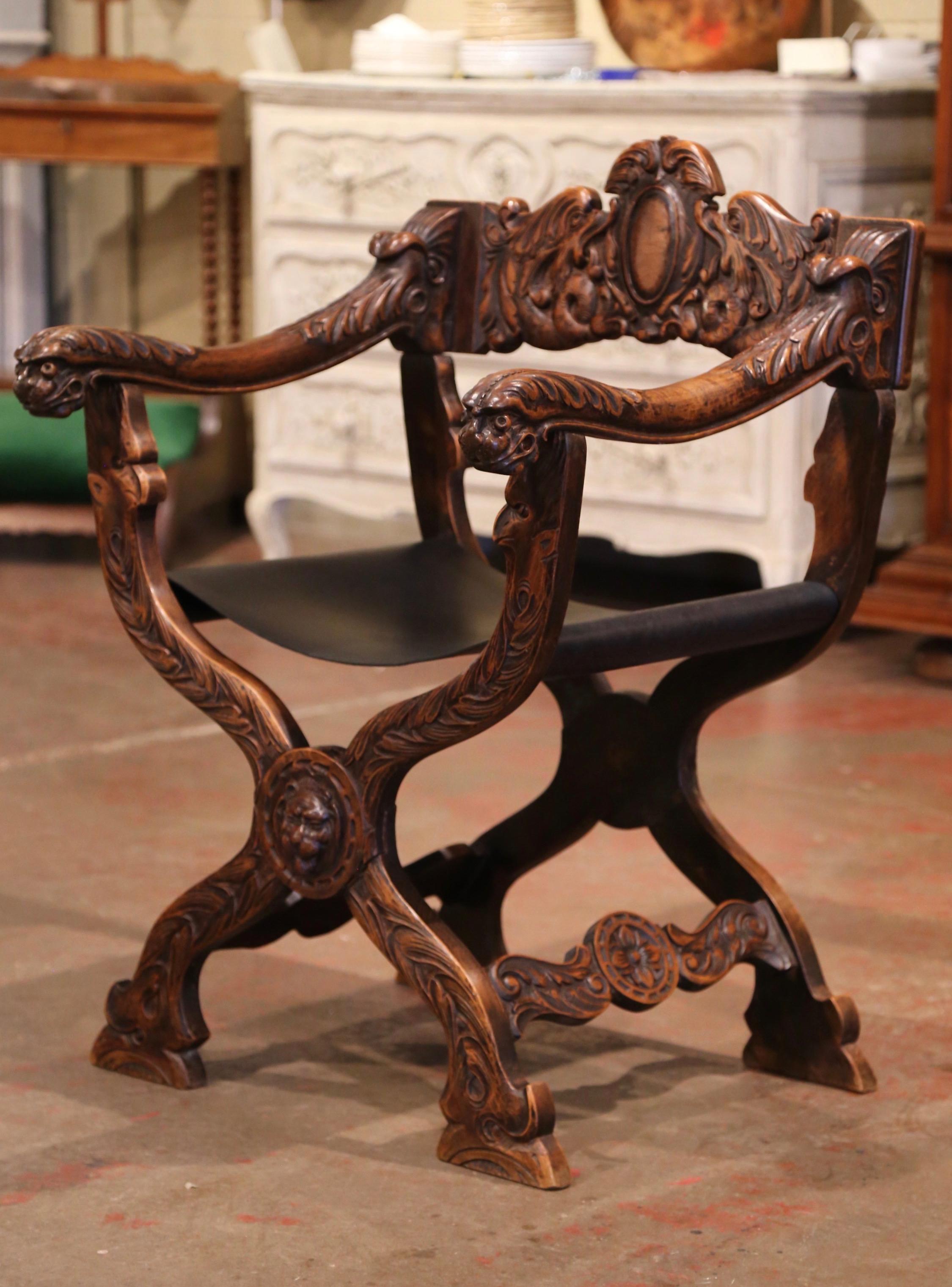 Decorate a man's study or office with this elegant and comfortable antique armchair; crafted in Italy circa 1870 and heavily carved, the fruitwood chair stands on a Curule base decorated in the center with a lion mask. The carved back with