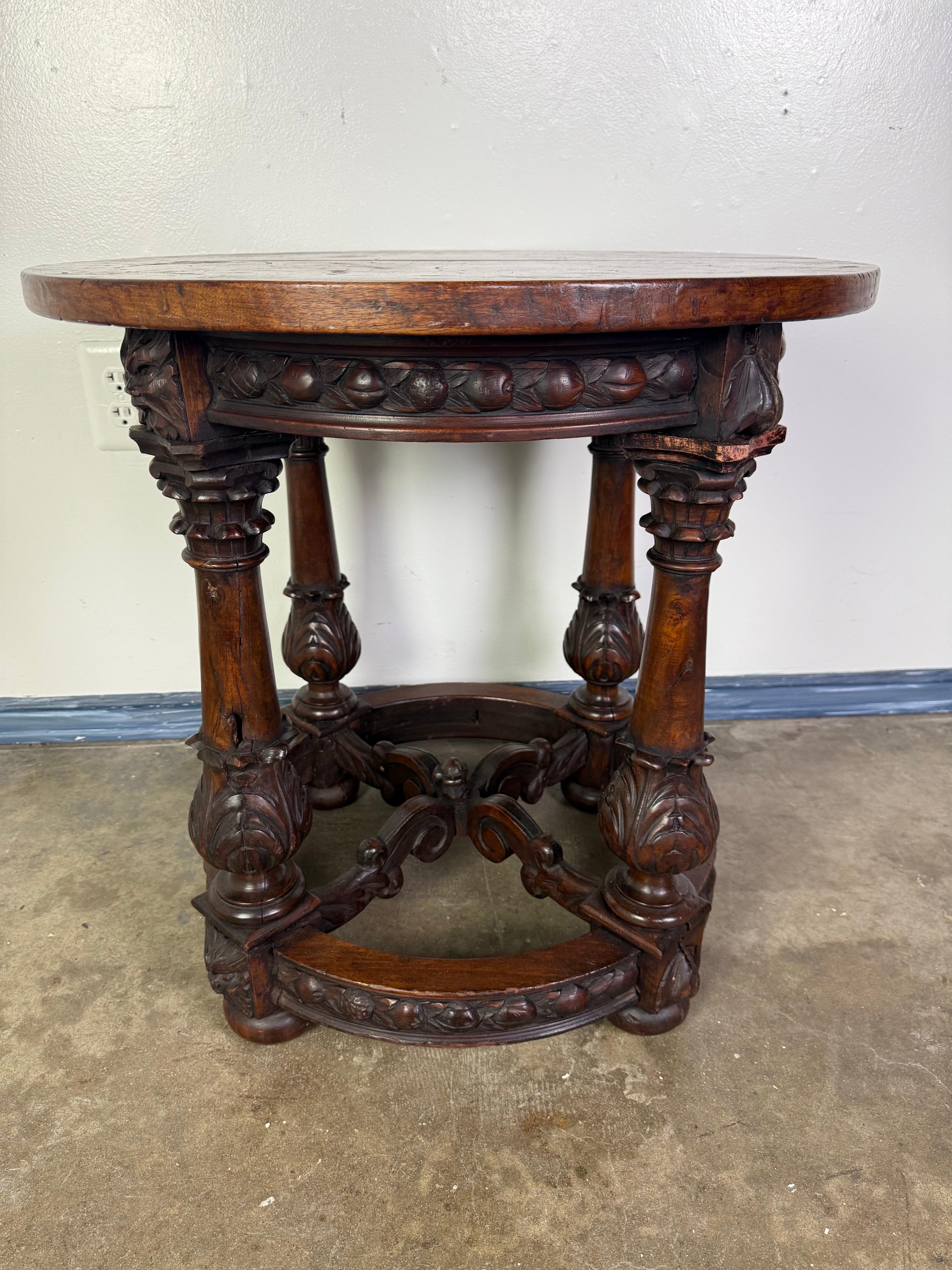 This exquisite mid-19th century Renaissance Revival center table showcases the fine craftsmanship and ornate detailing characteristic of the period. Expertly carved from rich walnut, the circular top is supported by four turned and deeply carved