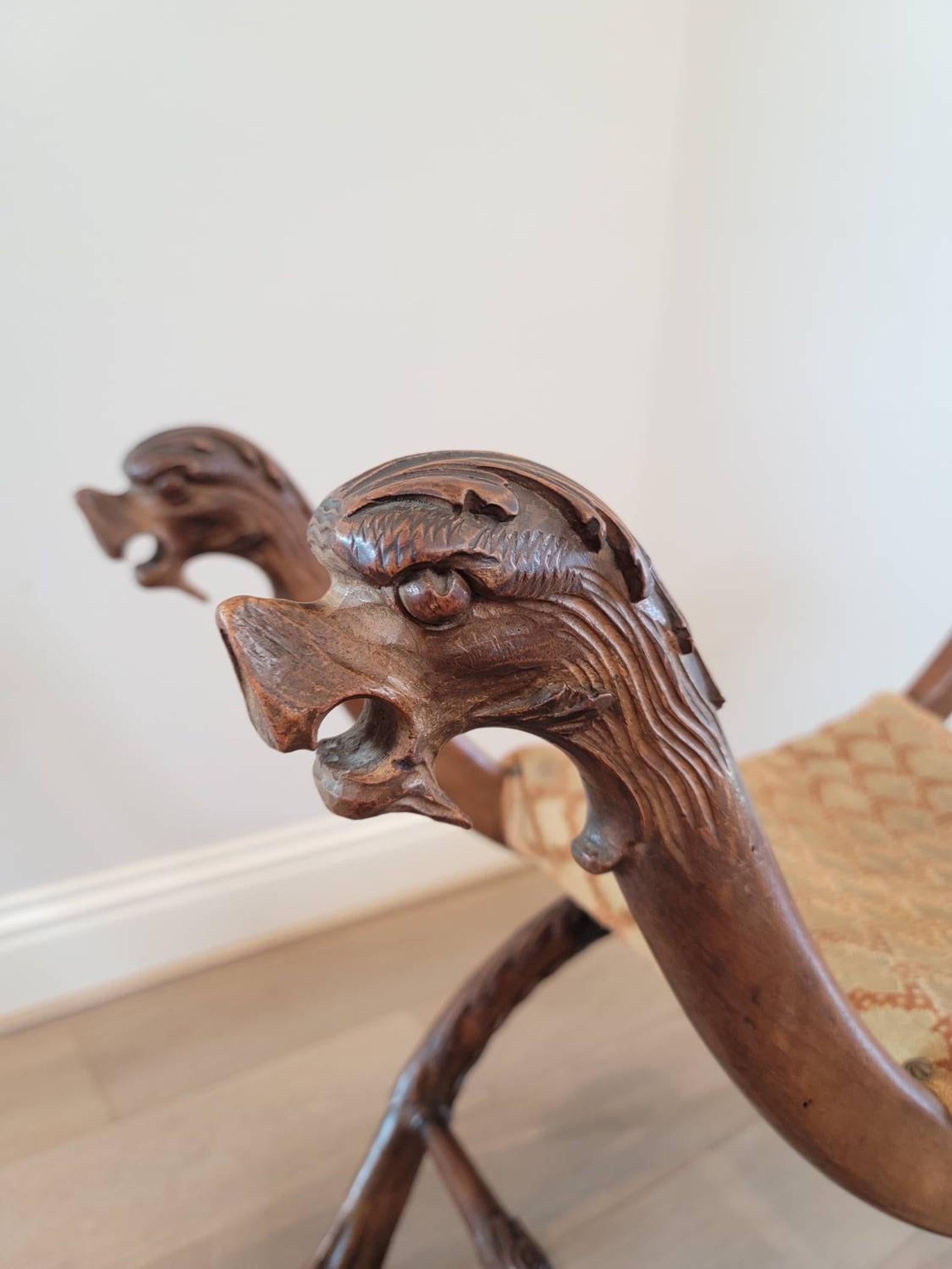 A exceptionally carved Italian Renaissance Revival figural curule stool.

Born in Italy during the late 19th century, hand-crafted of warm, rich, finely carved solid walnut, finished in medieval Henry II style / Italian Empire taste, featuring