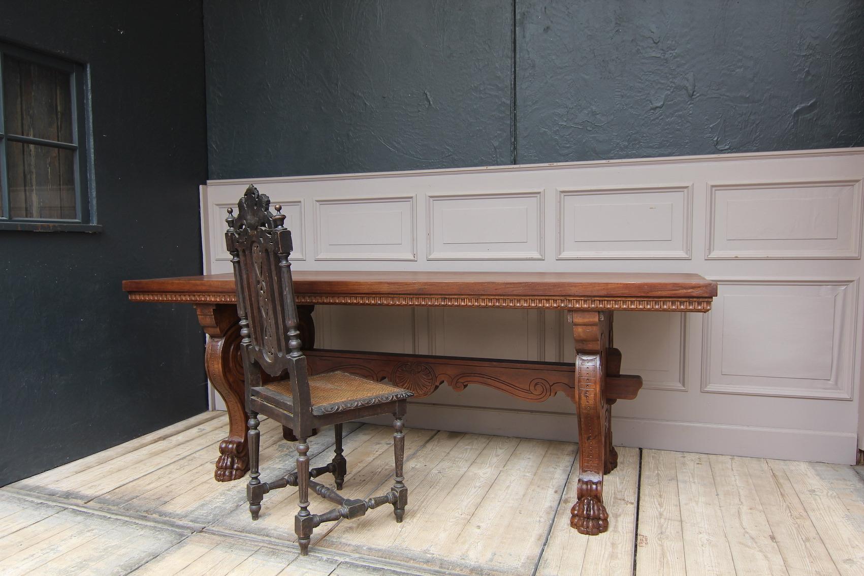 A 19th century Italian writing desk in renaissance revival style made of solid walnut.

The table can be used as a writing desk or as a dining table. Both sides look the same. 

Feet in the form of large double volutes that merge into