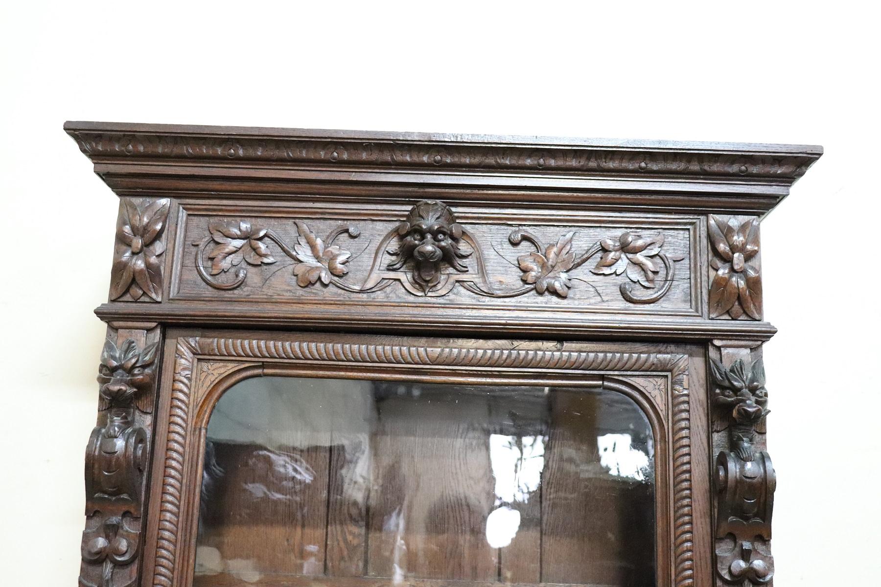 Impressive rare bookcase or sideboard in perfect Italian Renaissance style. Made of finely carved oakwood. The entire front part has rich carving in wood with zoomorphic figures. Feline feet carved in wood. The upper part with antique glass can be