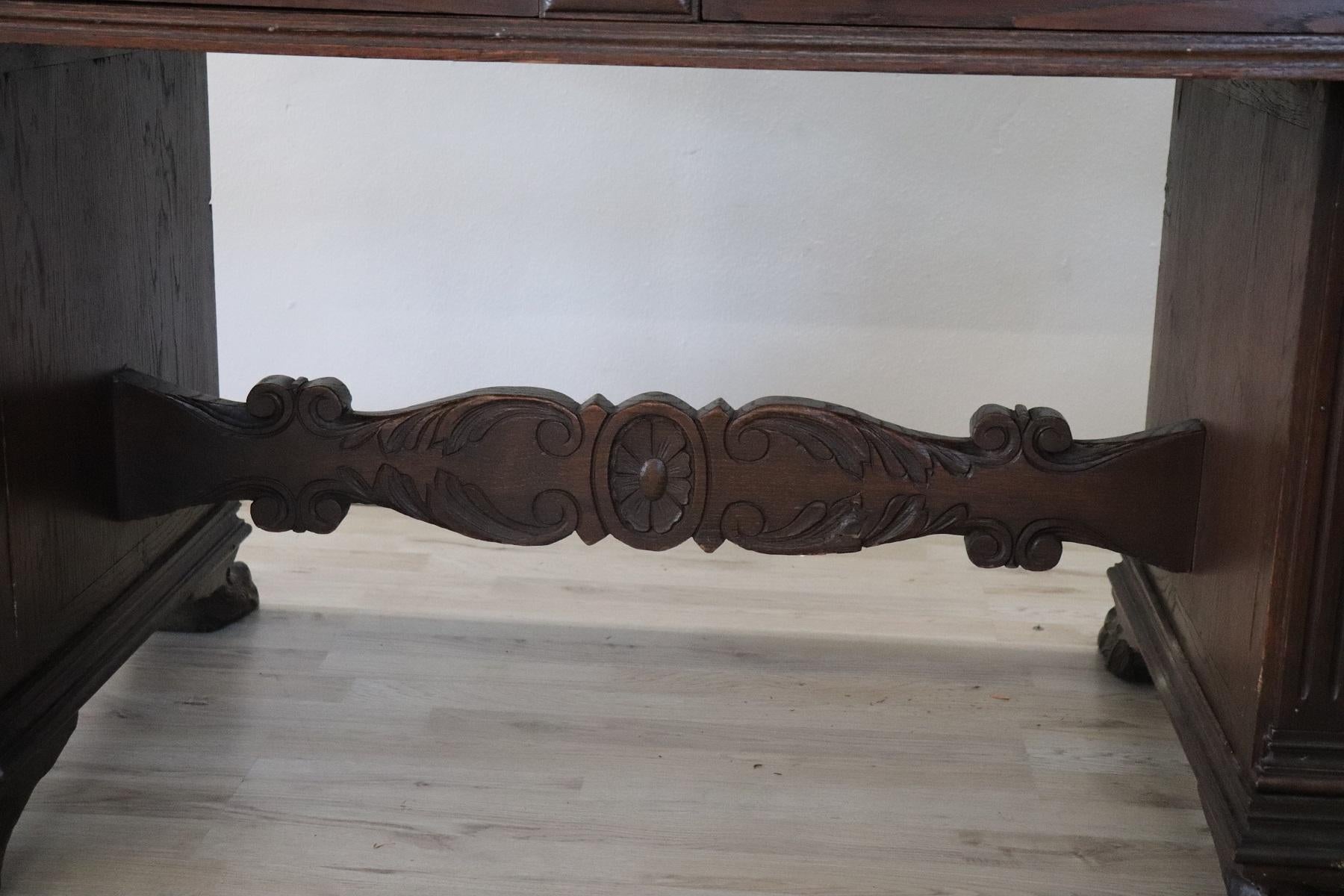 Beautiful antique rare Renaissance style writing table in carved oakwood. The sides present a refined carving decoration in wood of great artistic quality. The feet are made in the shape of a lion's paw. on the front two comfortable drawers. Medium