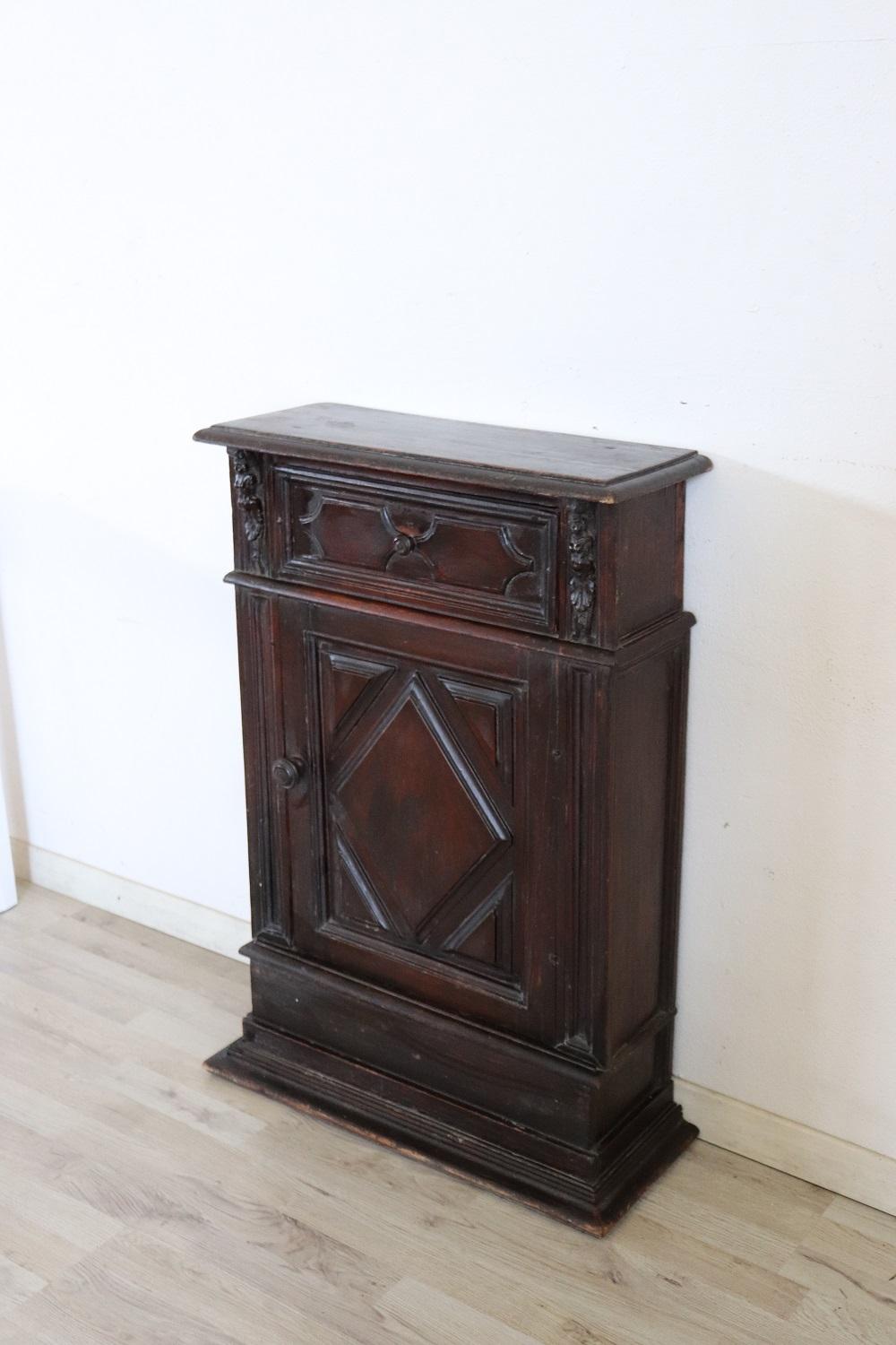 Rare and fine quality Italian renaissance style 1880s antique nightstand in carved solid walnut. On the front one comfortable drawer. Small figures carved in wood decorate the front. In antique good conditions. There are some signs of wear and age.