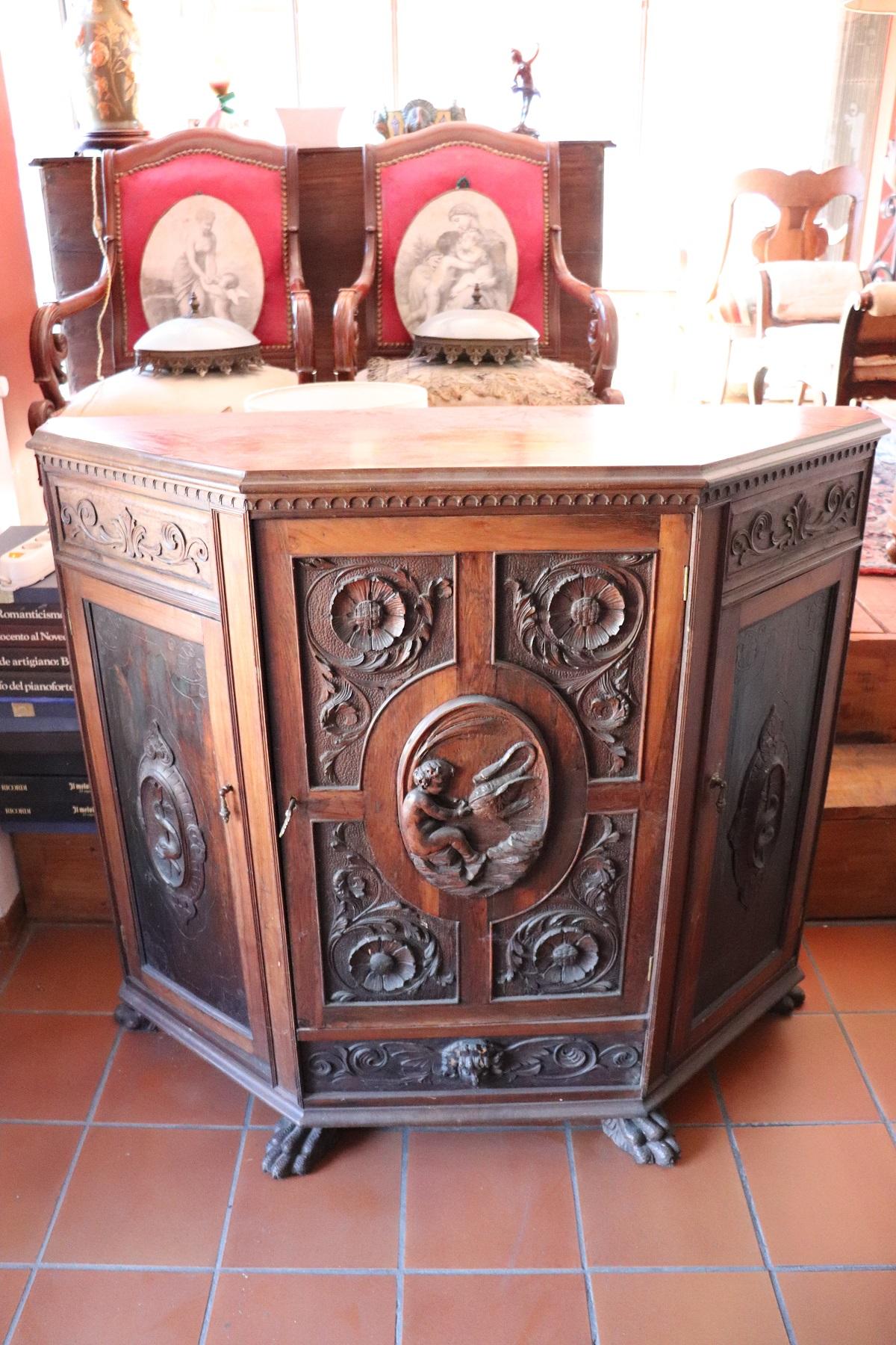 Beautiful rare large sideboard from the 19th century in carved walnut wood. Walnut wood has a beautiful light patina. Door panels finely carved in walnut wood. On the front a sweet child playing with a swan. Ample useful internal space with refined