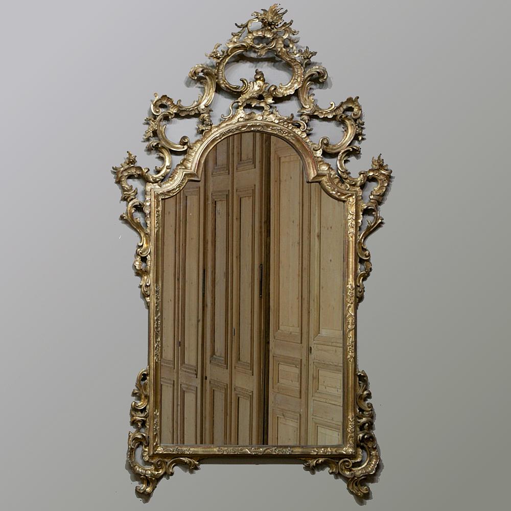 19th century Italian Rococo hand carved giltwood mirror has been carved from solid wood, no plaster like you see on the French mirrors from the period, then carefully water gilded for a truly amazing and opulent effect. Note the stylized shell and