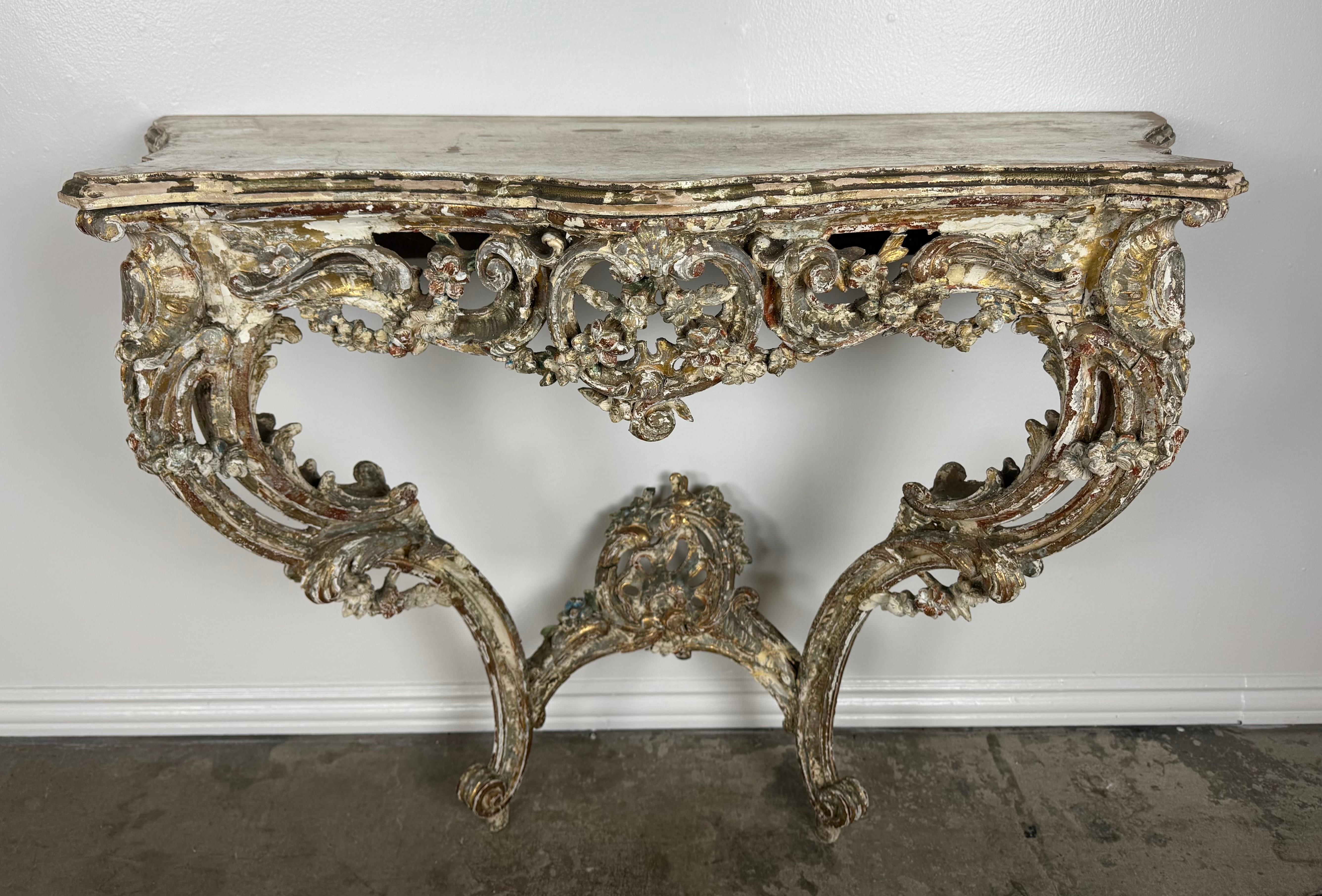 A beautifully timeworn and sculptural 19th-century Italian Rococo console, exquisitely carved in bold, asymmetrical scrolls and pierced floral motifs. This dramatic wall-mount console displays the fluidity and exuberance characteristic of late-18th