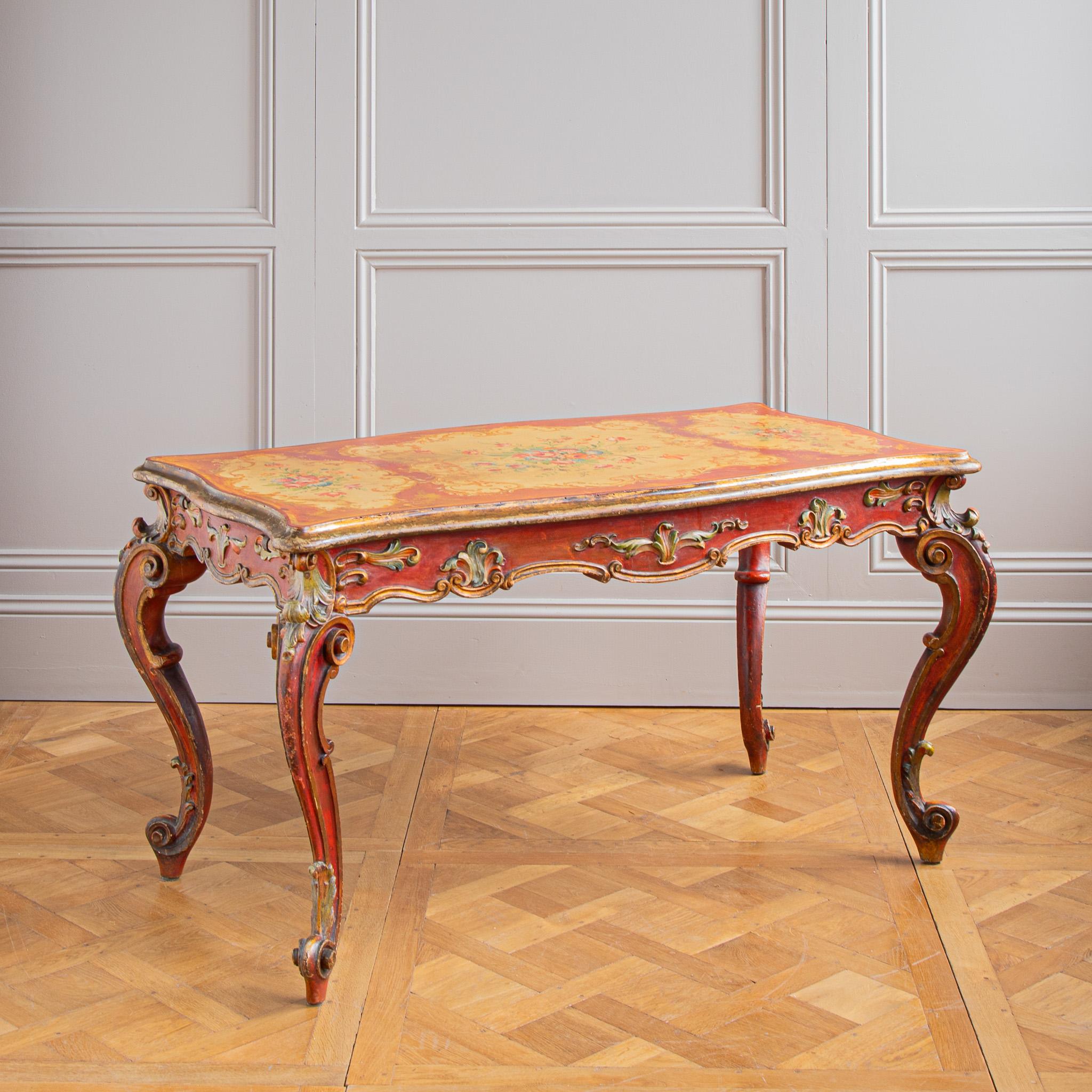 Table de la fin du XIXe siècle de style rococo, peinte à la main dans le style vénitien. Cette table italienne, qui peut également servir de bureau, présente des volutes finement sculptées à la main sur les pieds cabriole. Le tablier de la table