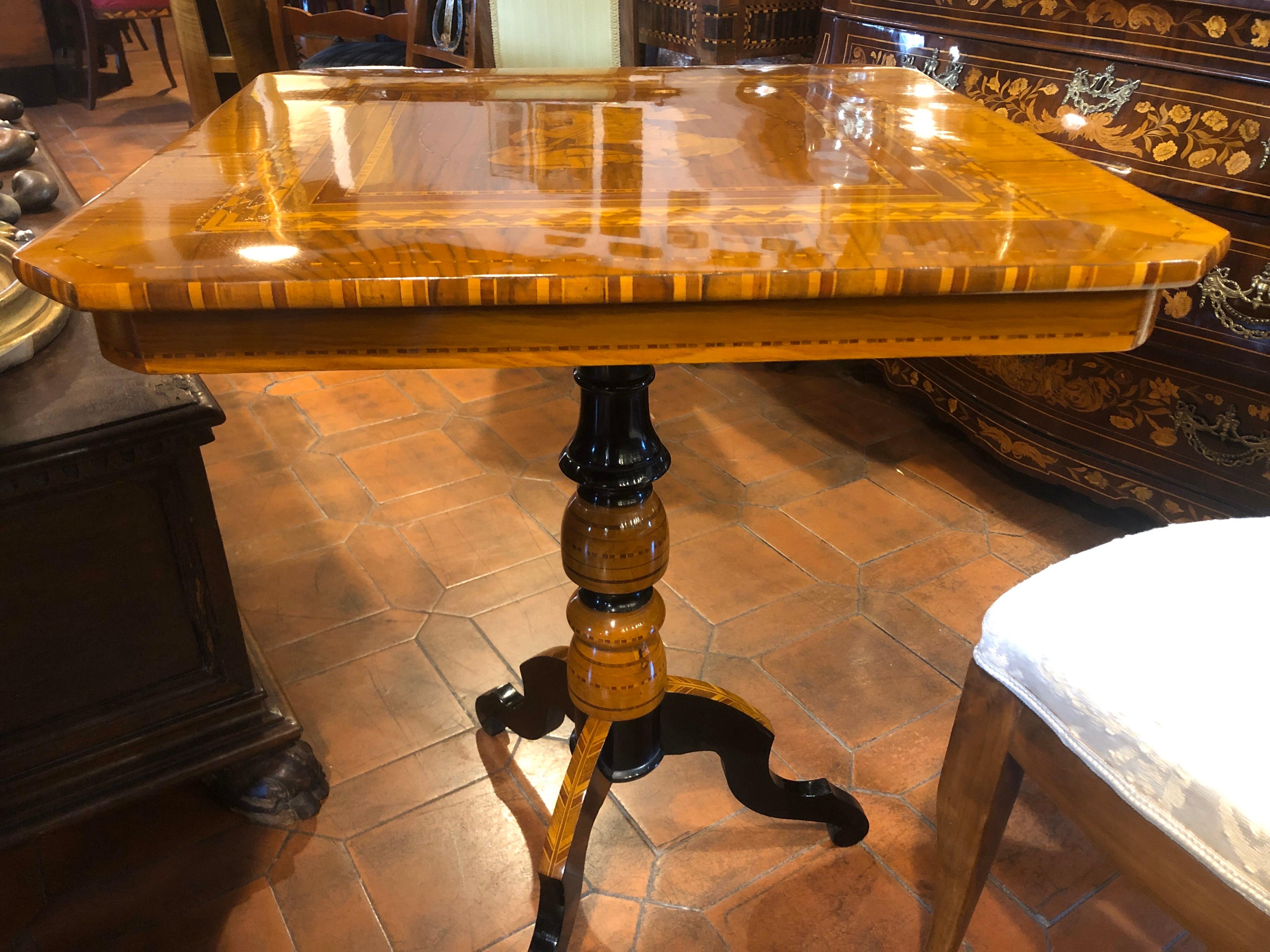 Table of Emilian origin, city of Rolo, finely inlaid in polychrome woods, in the center there is depicted San Giorgio and the Dragon; the furniture has been restored in the old way, only spirit and shellac. On the basis we have both geometric inlays