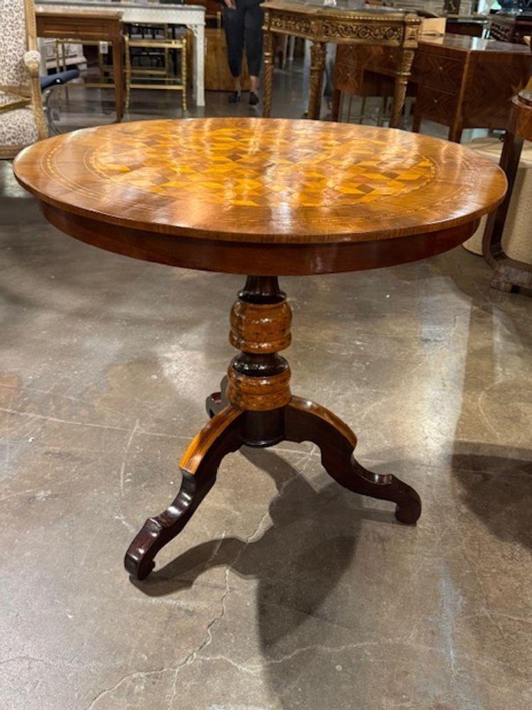 The 19th Century Italian Round Inlaid Table is a beautiful piece of antique furniture that exudes elegance and charm. Featuring a graphic inlaid design and a polished  finish, this table showcases the intricate craftsmanship and attention to detail