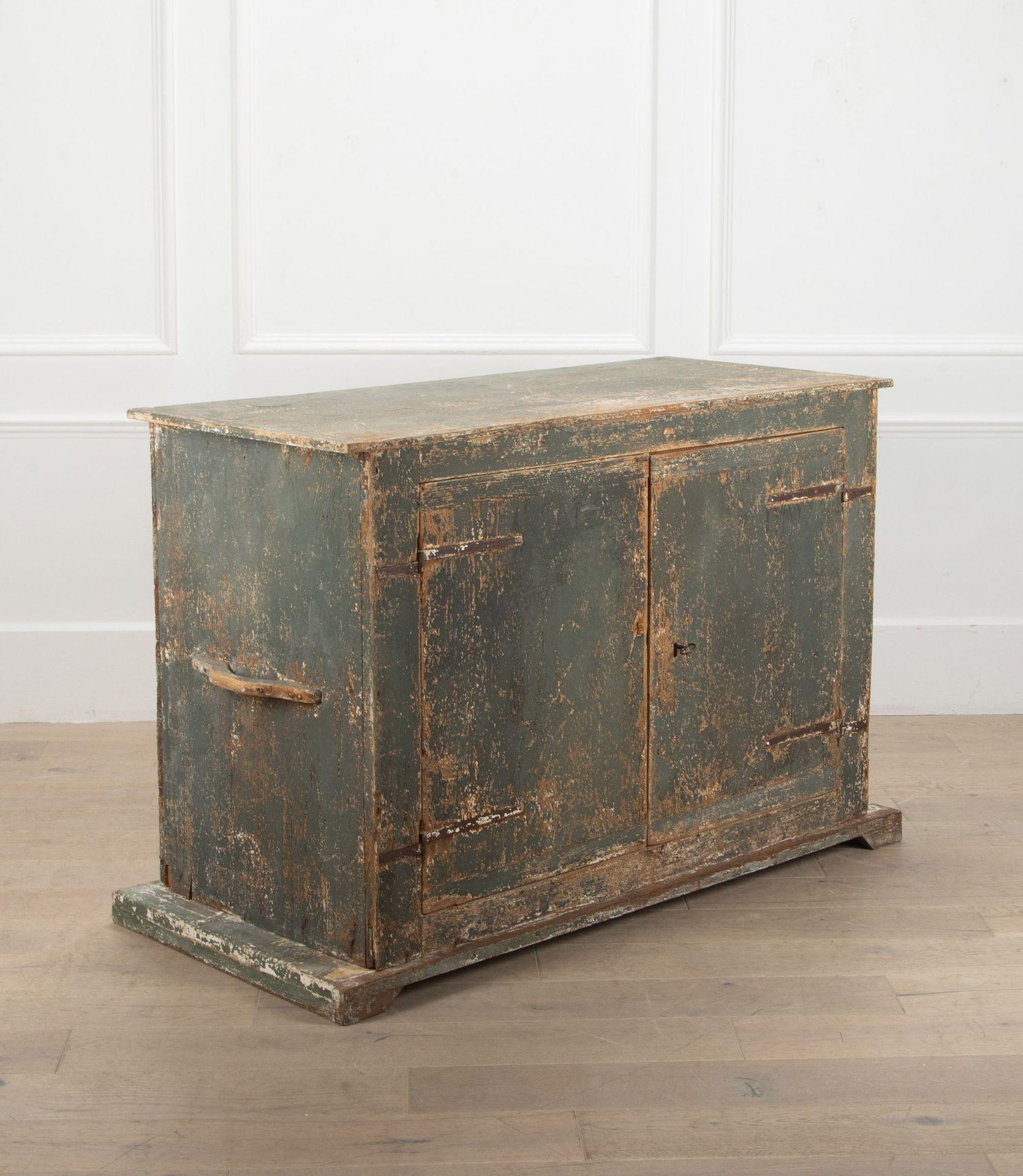 Early 19th Century Italian buffet or credenza with pale grey green paint and hand forged iron hinges.
A simple, rustic piece with two doors and three shelves inside.
The two sturdy handles on the sides makes one suspect it could have been a military